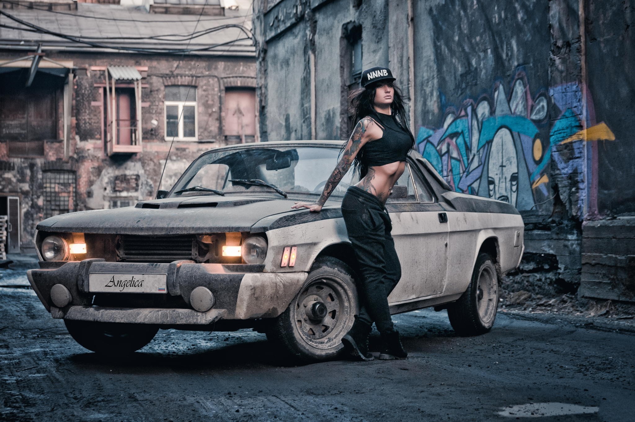 Woman leaning on a vintage car in an alley HD Wallpaper