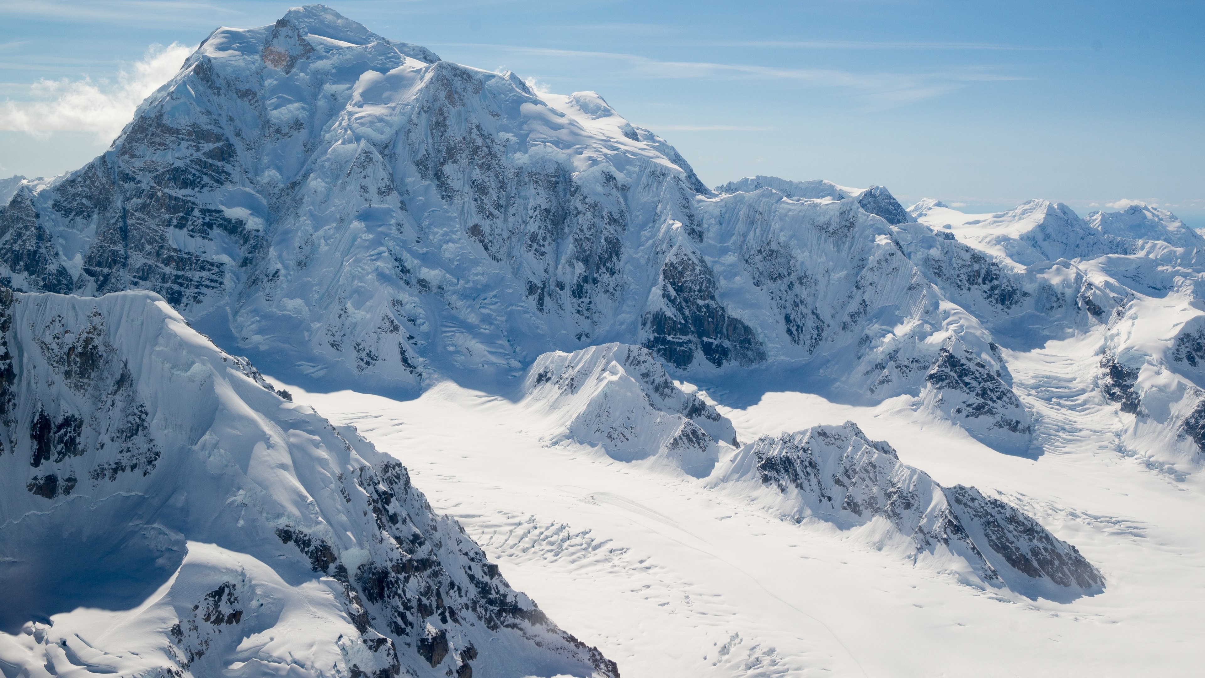 Snow-covered mountains under a blue sky HD Wallpaper