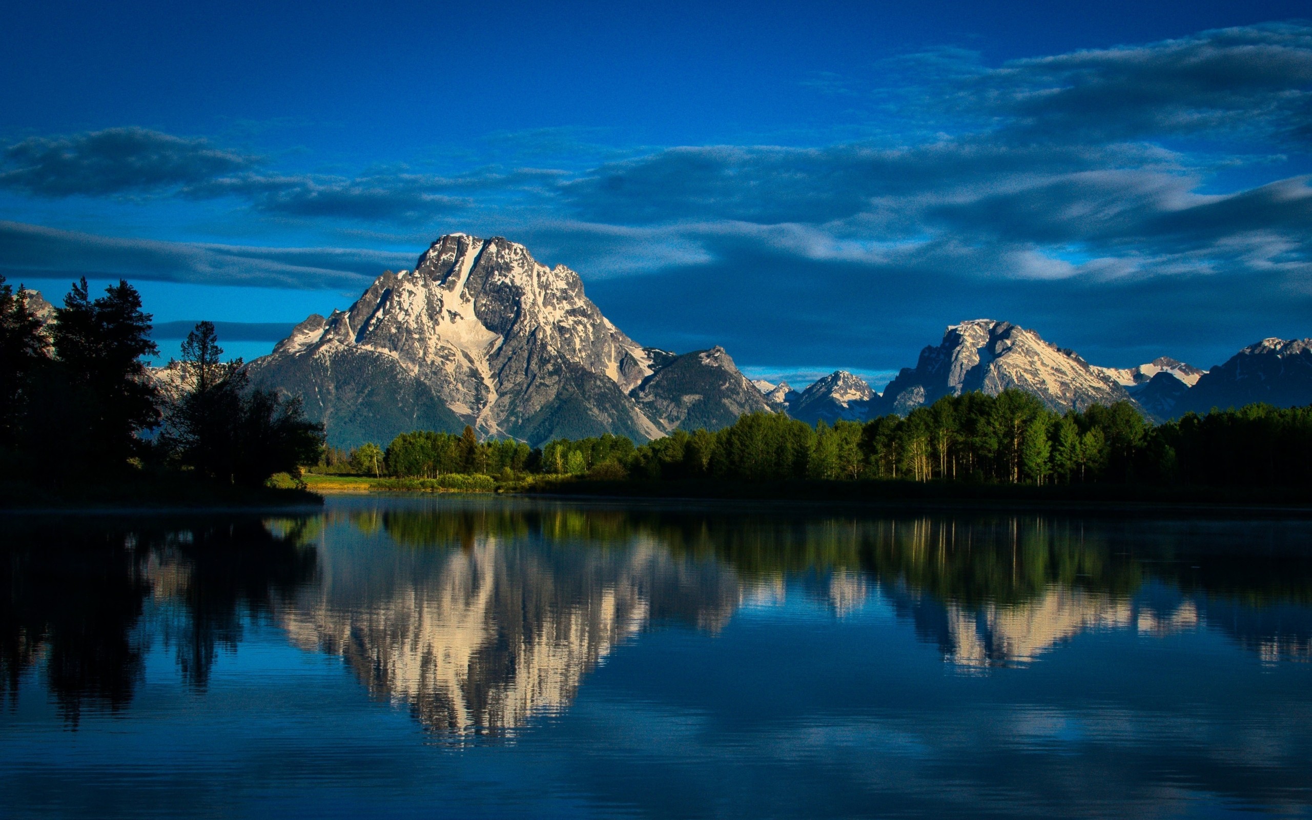 Snow-capped mountains reflected in a calm lake HD Wallpaper
