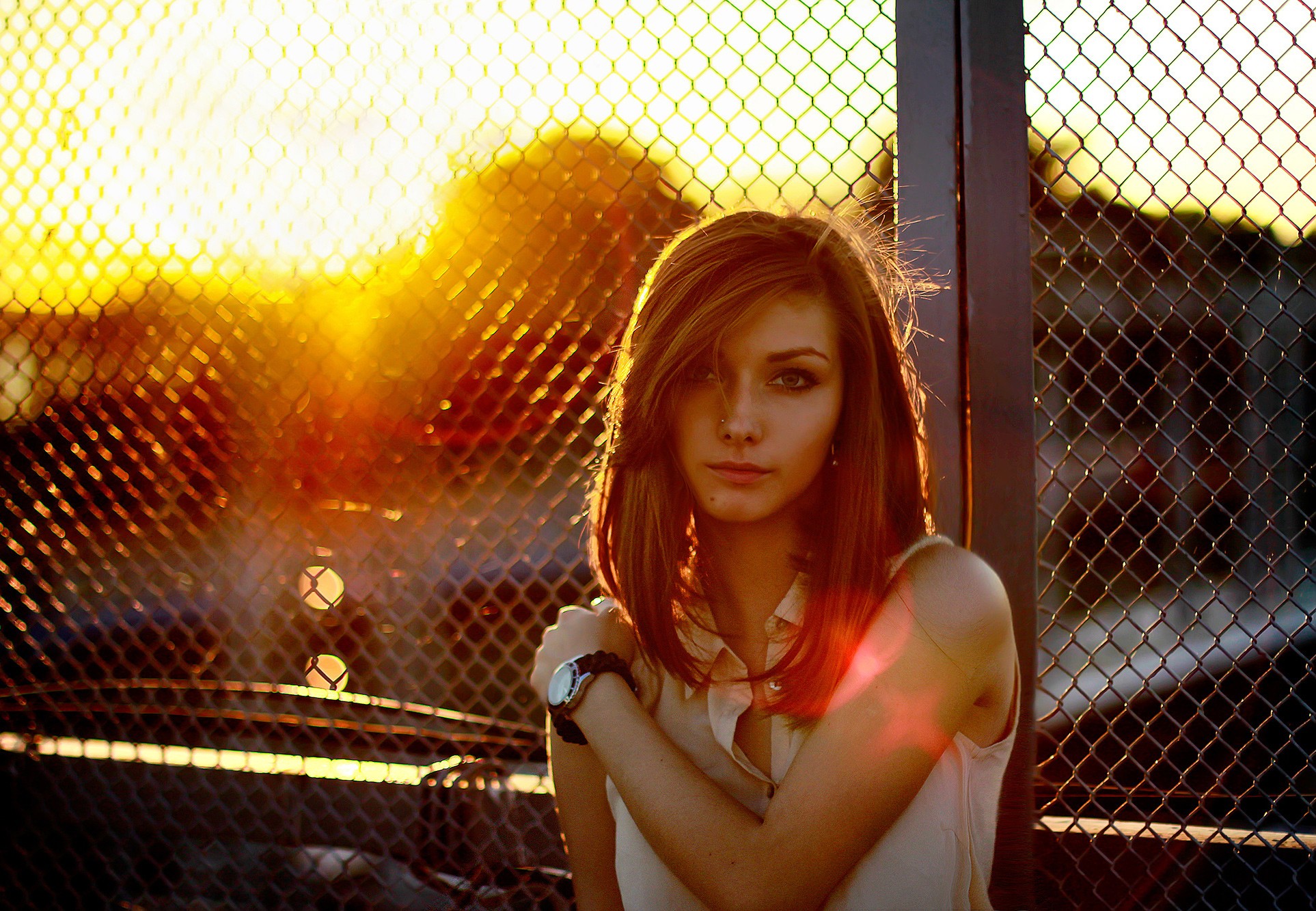 Woman leaning against a fence at sunset HD Wallpaper