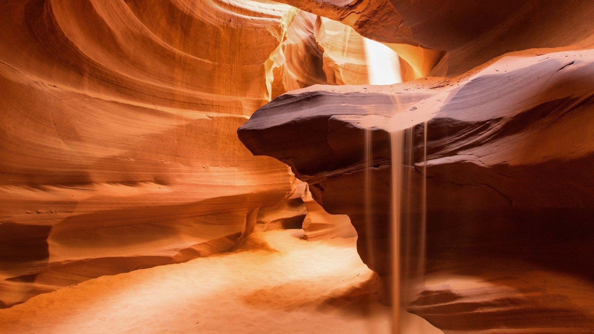 Sand falling in a desert canyon HD Wallpaper