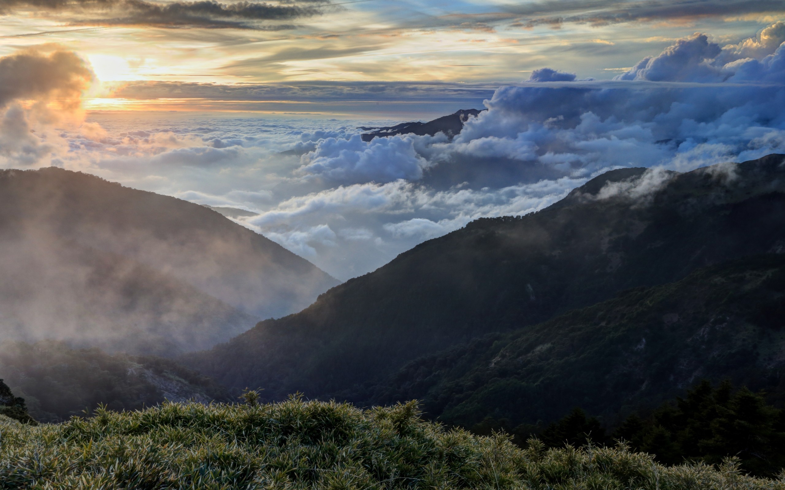 Sunset over mountains with clouds and grass HD Wallpaper