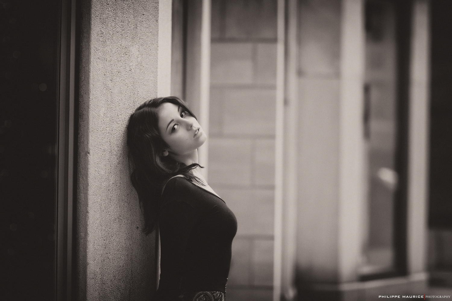 Woman leaning against a textured wall HD Wallpaper