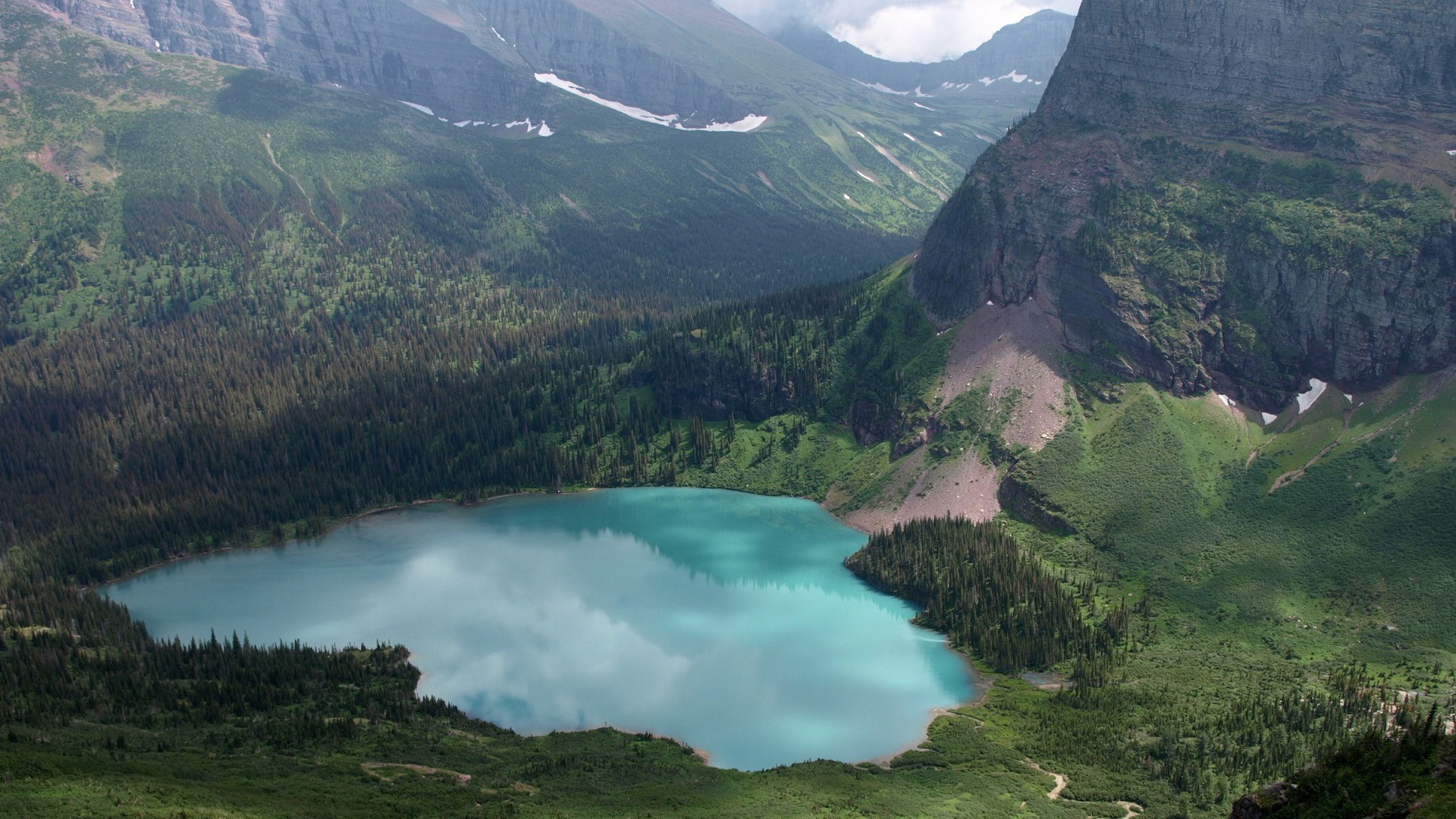 Turquoise lake surrounded by pine trees and mountains HD Wallpaper