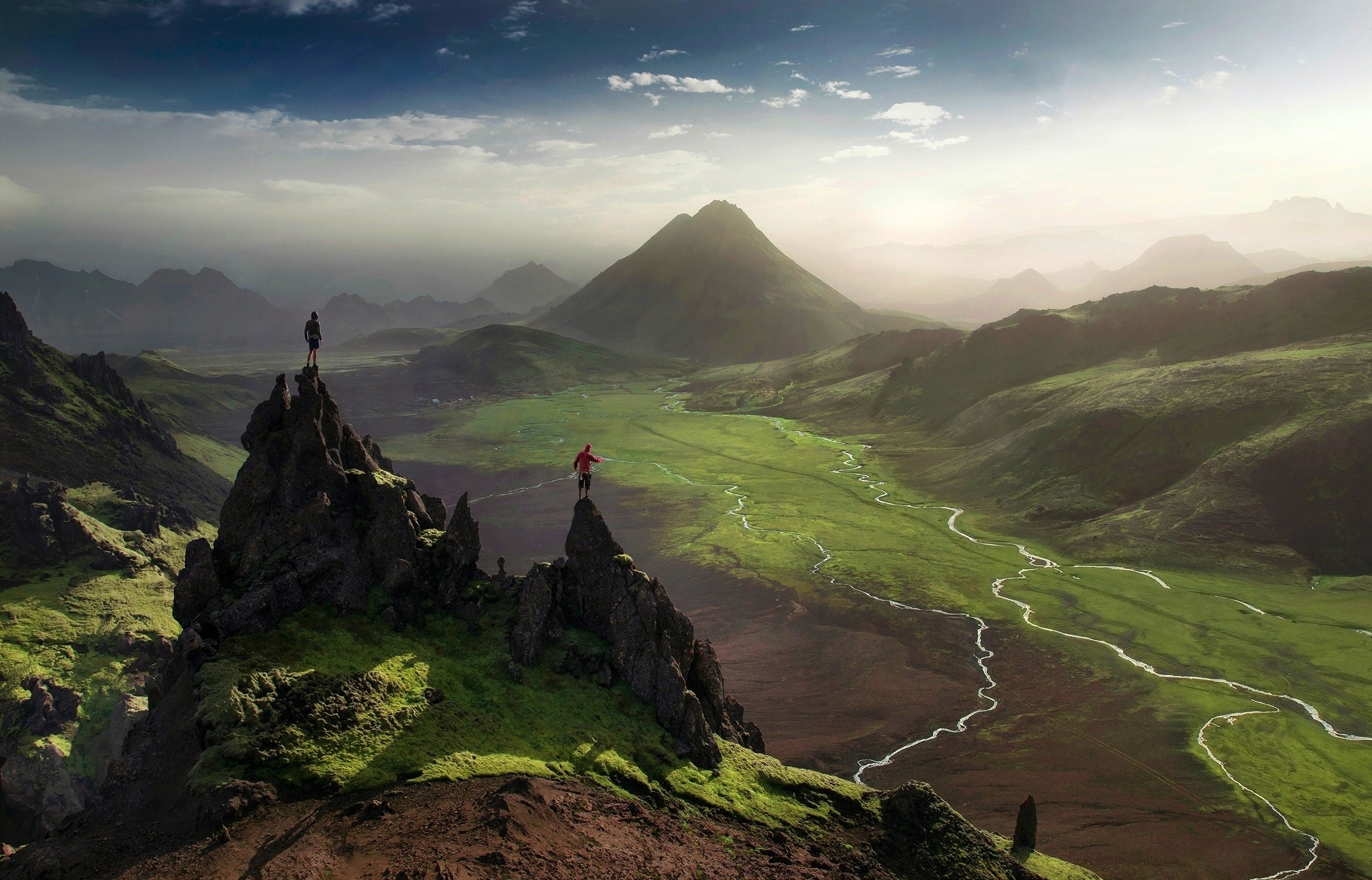 Two people slacklining between rocky peaks in Iceland HD Wallpaper