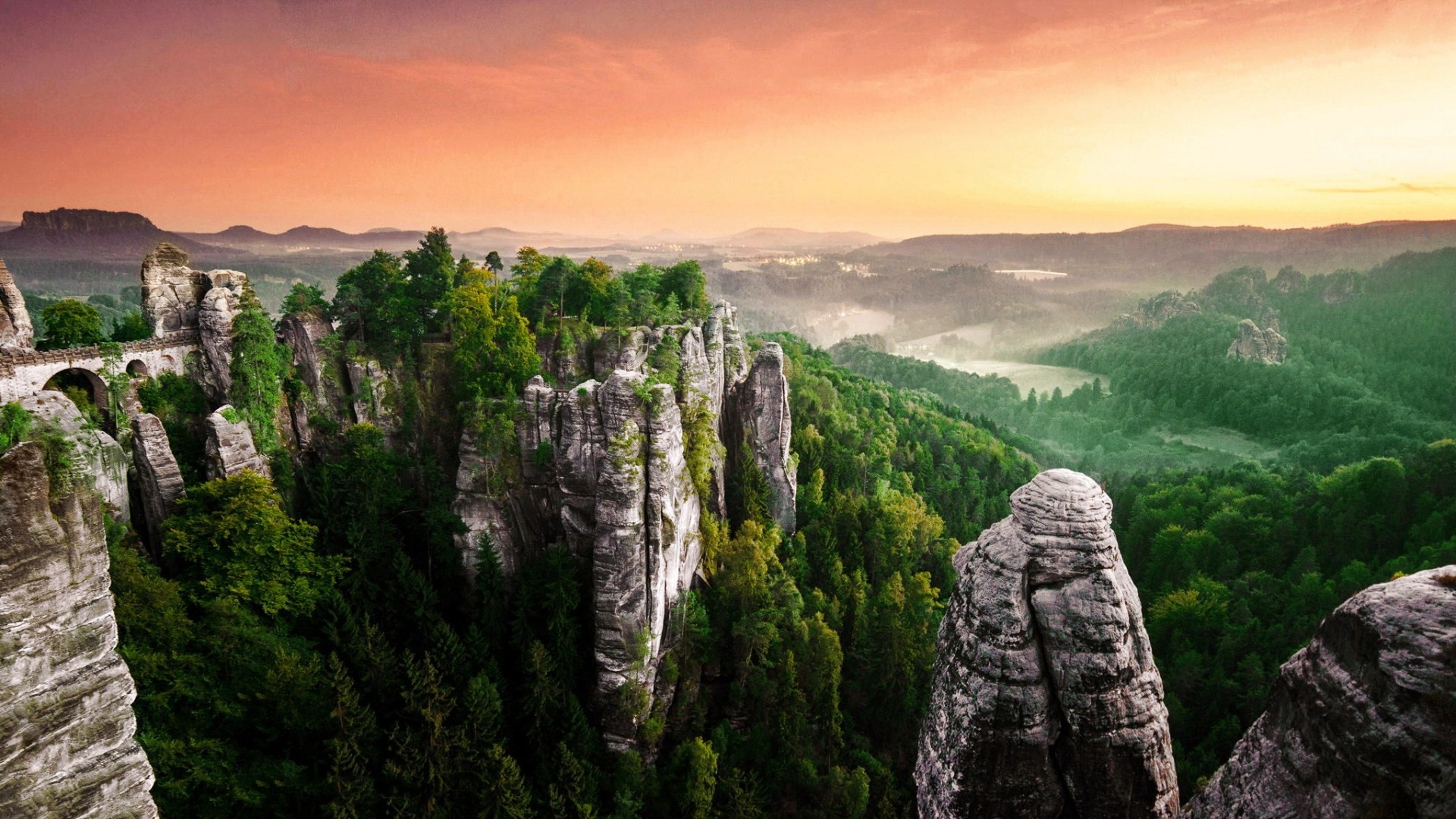 Bastei Bridge over rocky forest landscape at sunset HD Wallpaper