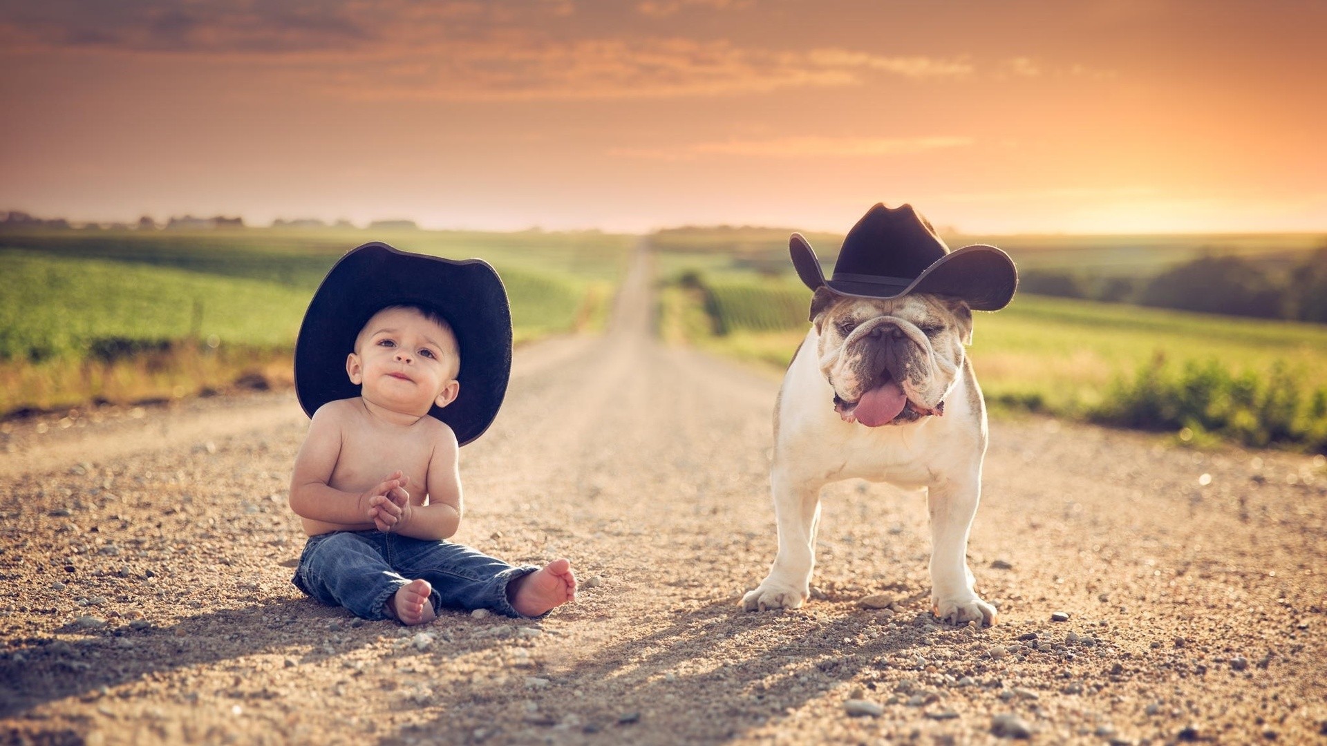 Baby and bulldog wearing cowboy hats on a dirt road HD Wallpaper