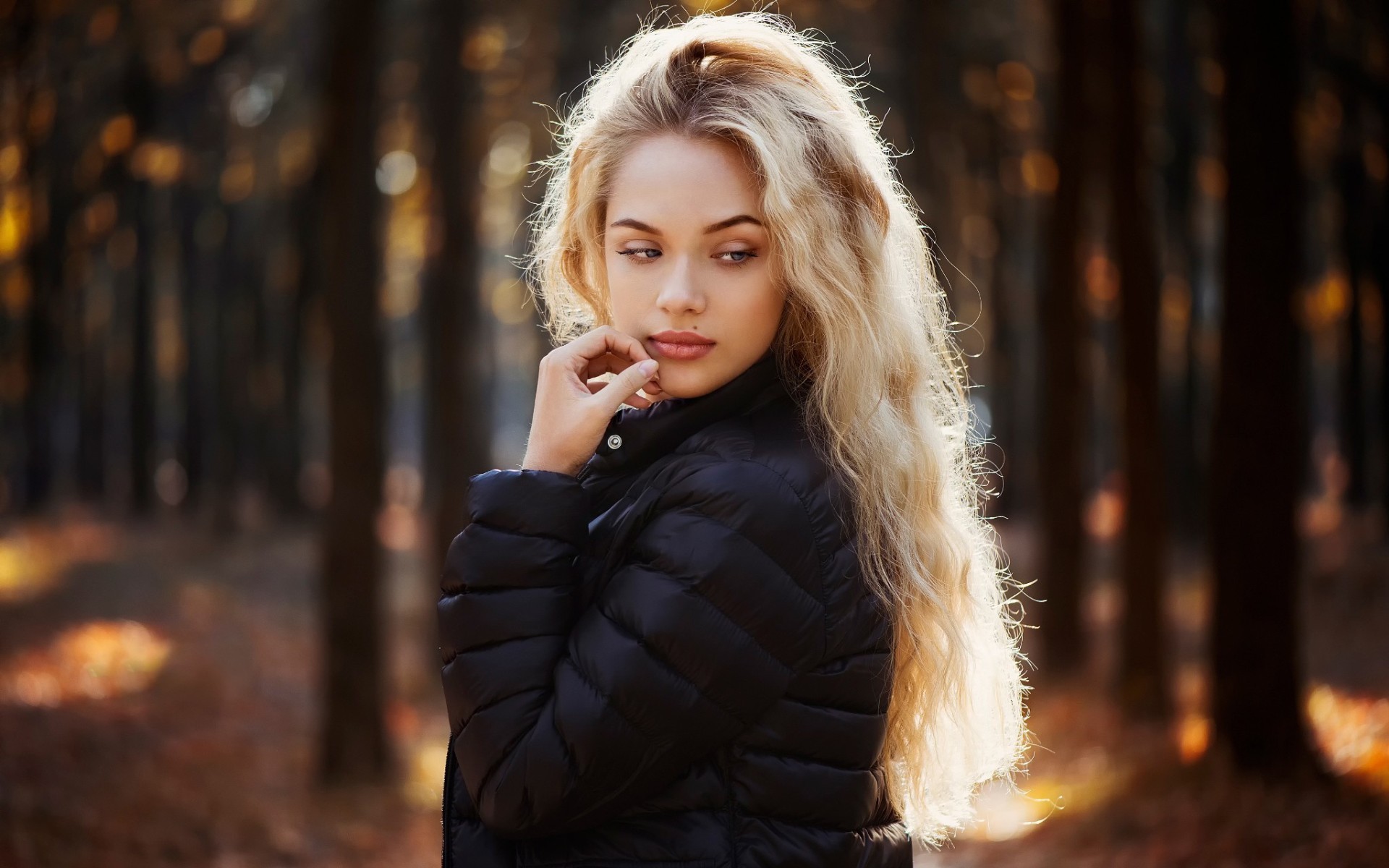 Woman with long blonde hair in a black jacket outdoors HD Wallpaper