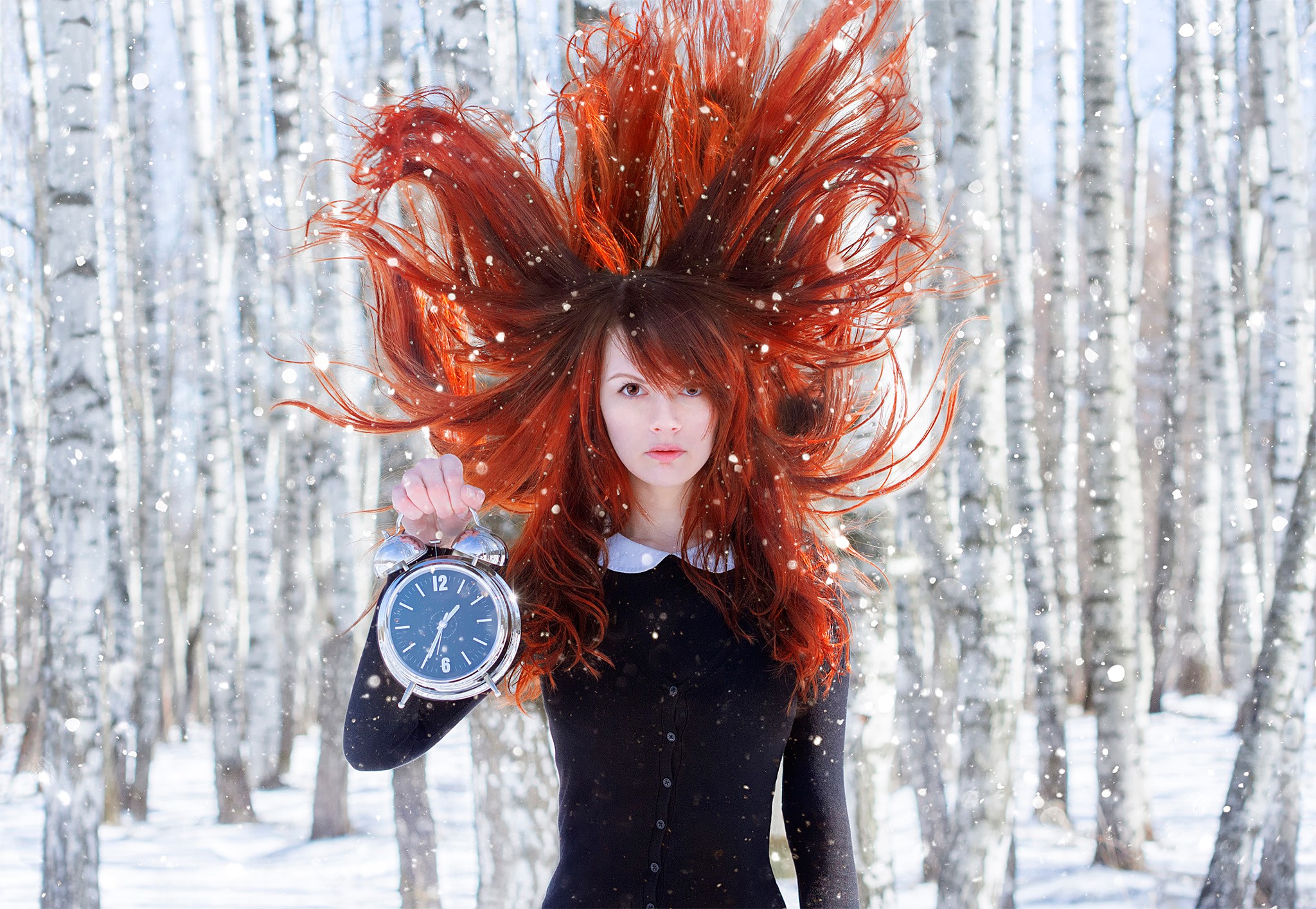 Redhead woman holding alarm clock in snowy birch forest HD Wallpaper