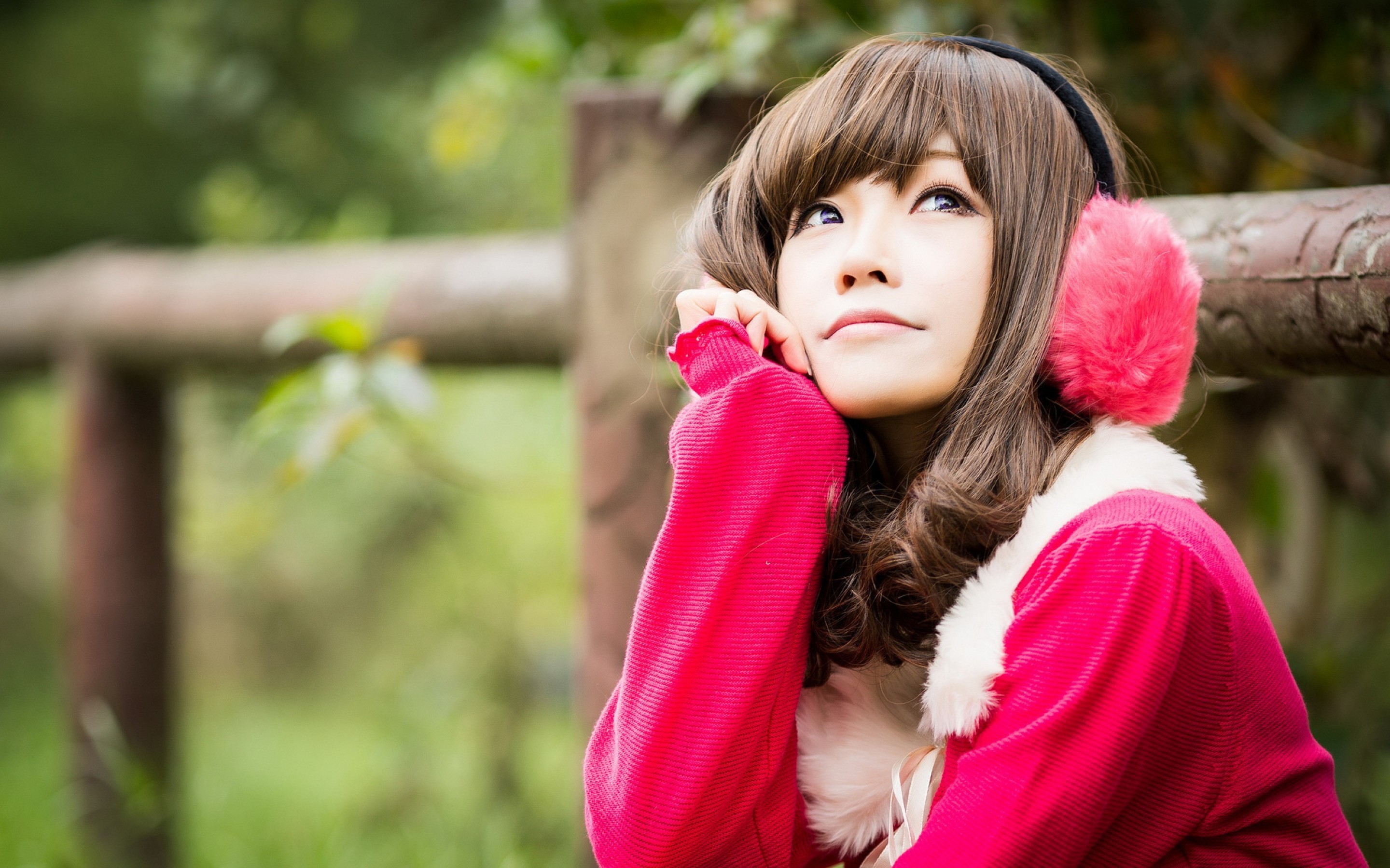 Young woman with brown hair and pink earmuffs HD Wallpaper