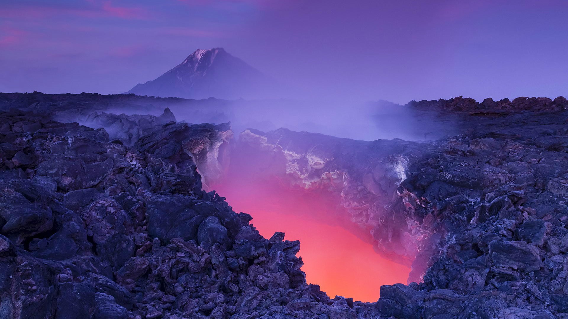 Molten lava pit in Kamchatka, Russia with a volcano in the background HD Wallpaper
