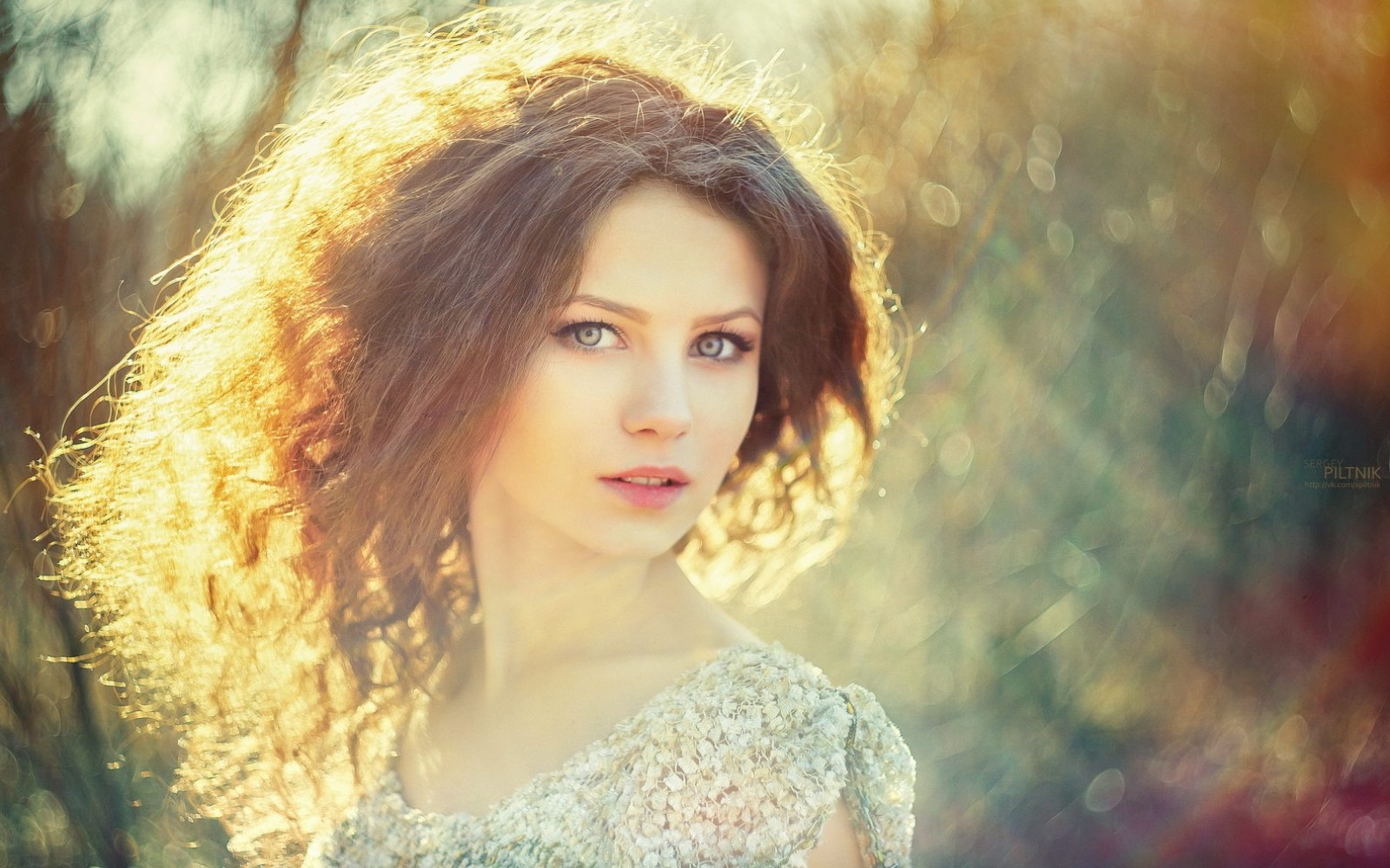 Woman with curly hair and blue eyes in sunlight HD Wallpaper