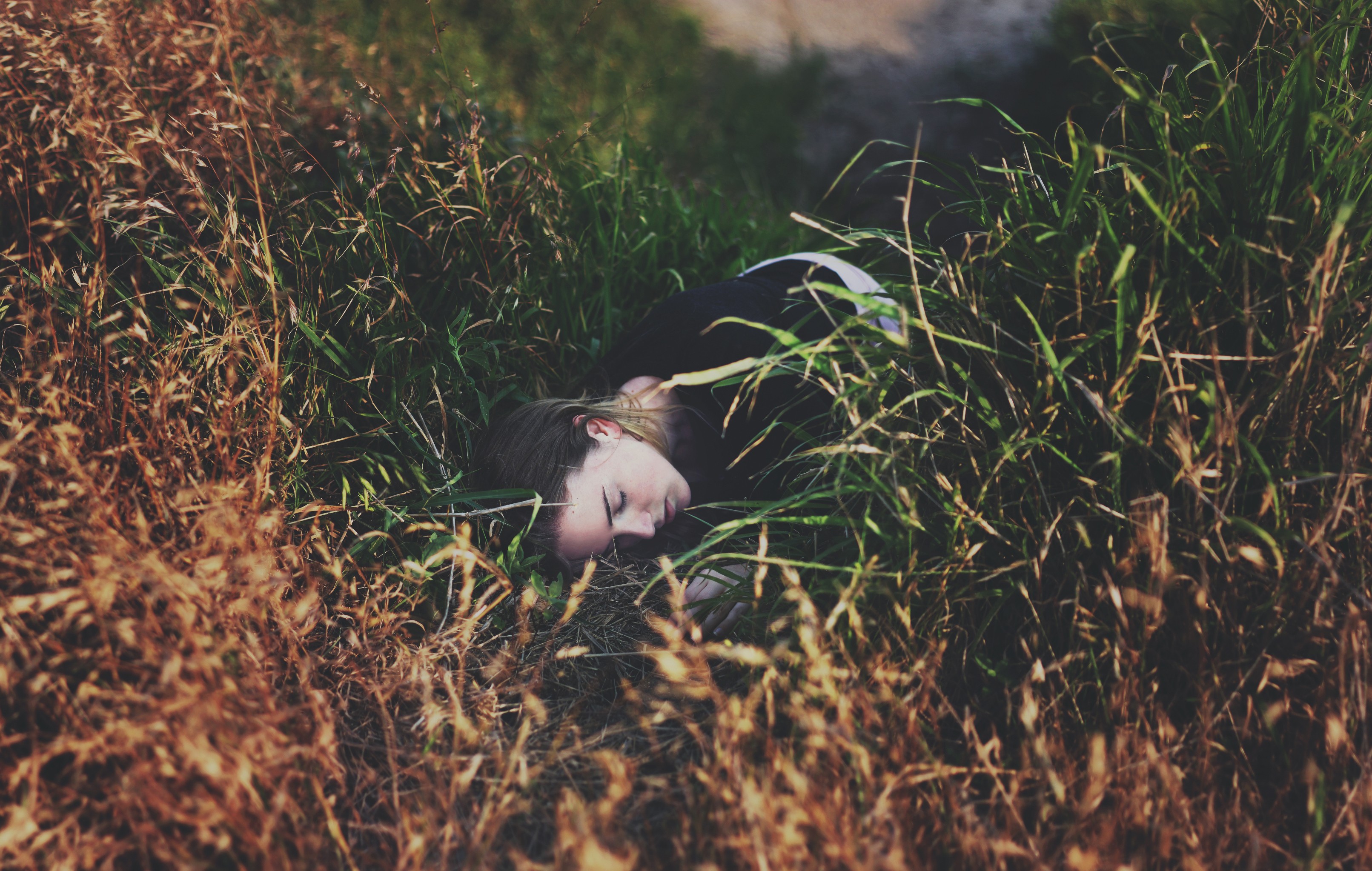 Woman sleeping in tall grass outdoors HD Wallpaper