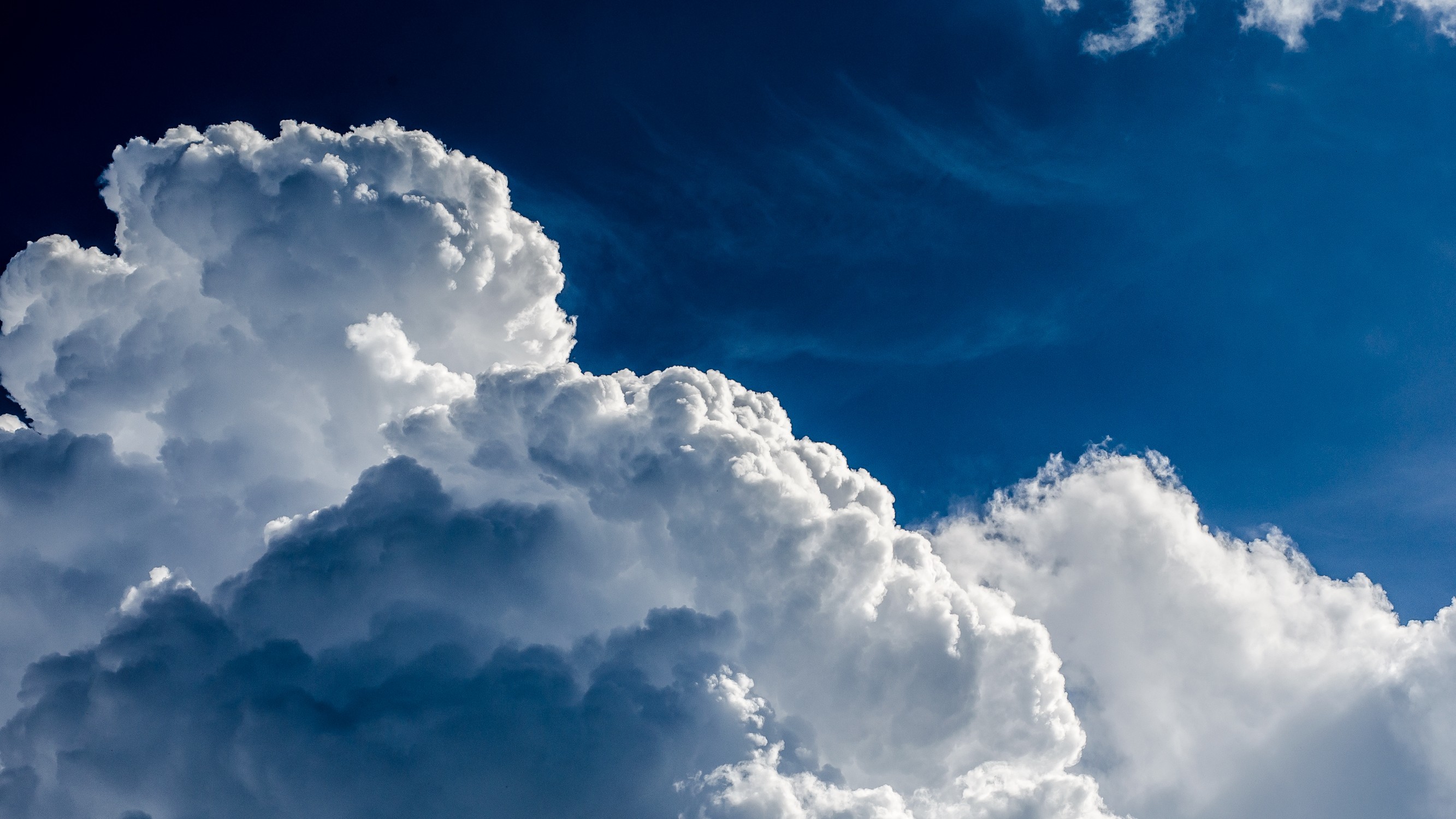 Dramatic clouds against a deep blue sky HD Wallpaper