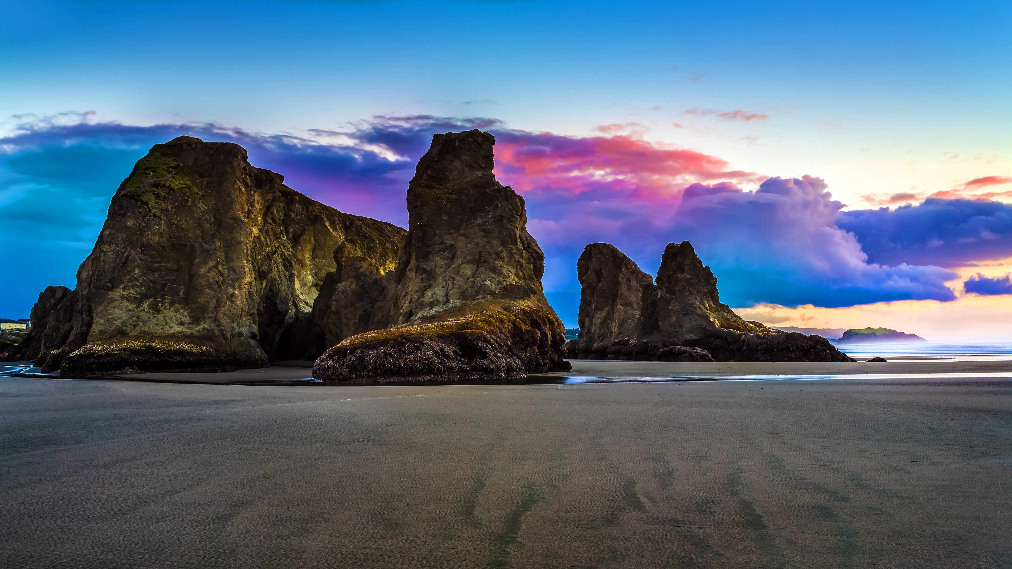 Rock formations on a sandy beach at sunset HD Wallpaper