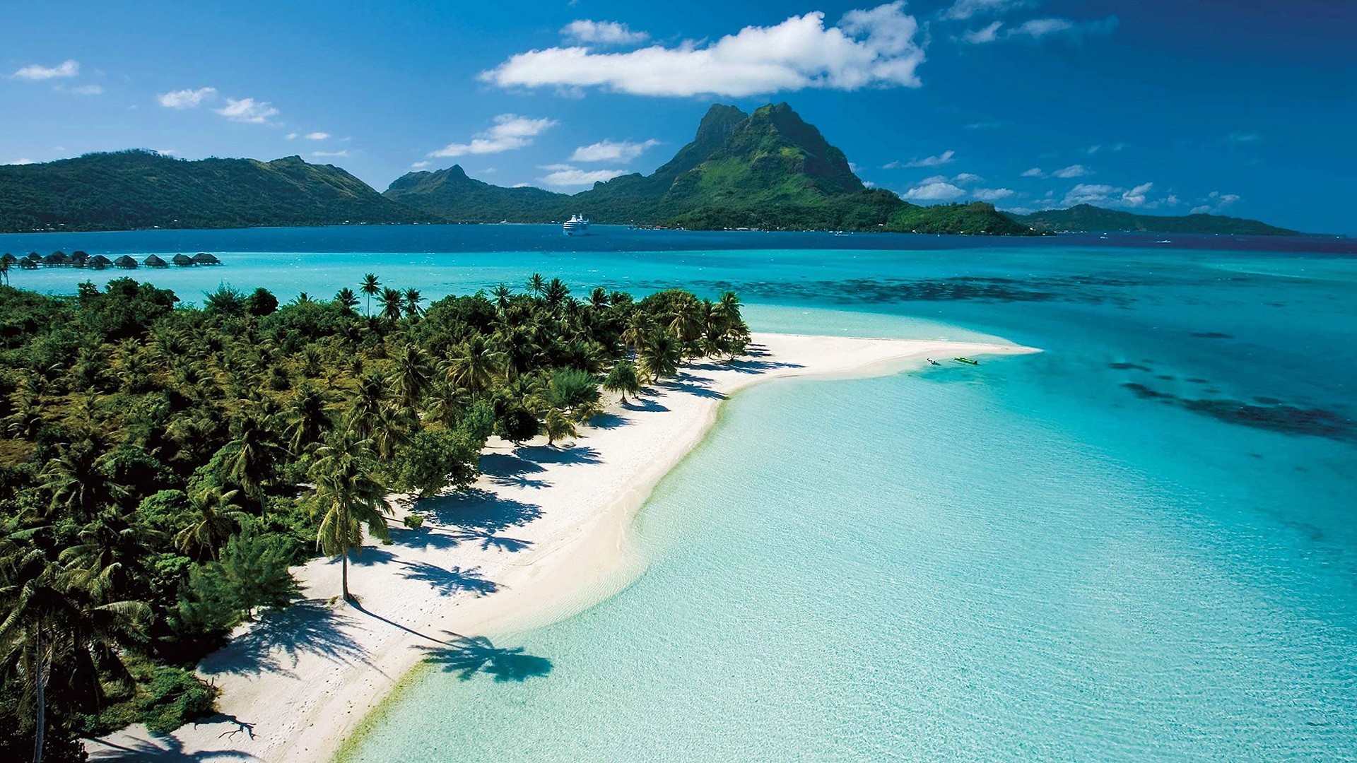 Tropical island with overwater bungalows and mountains HD Wallpaper
