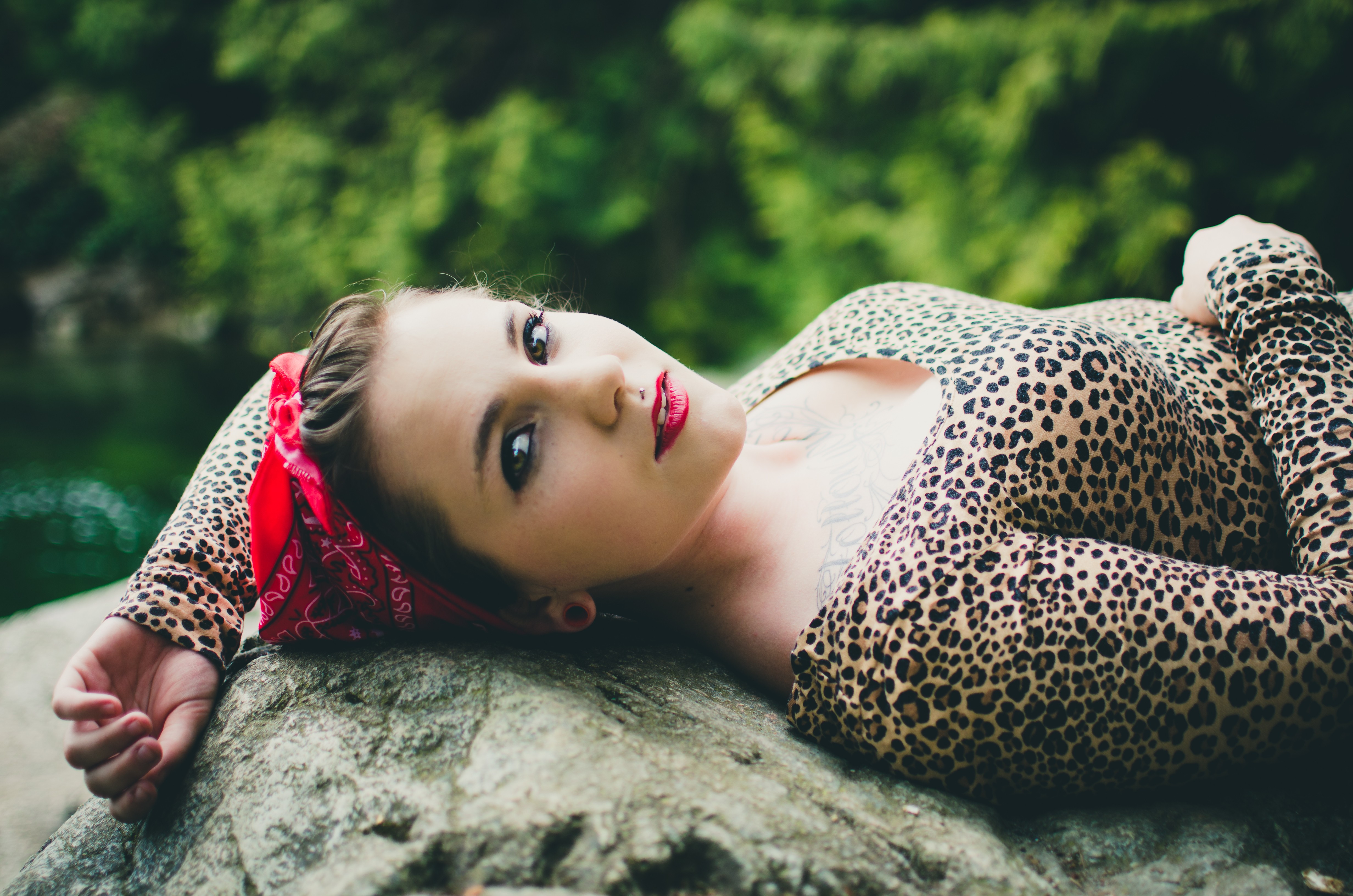 Woman in animal print lying on a rock outdoors HD Wallpaper