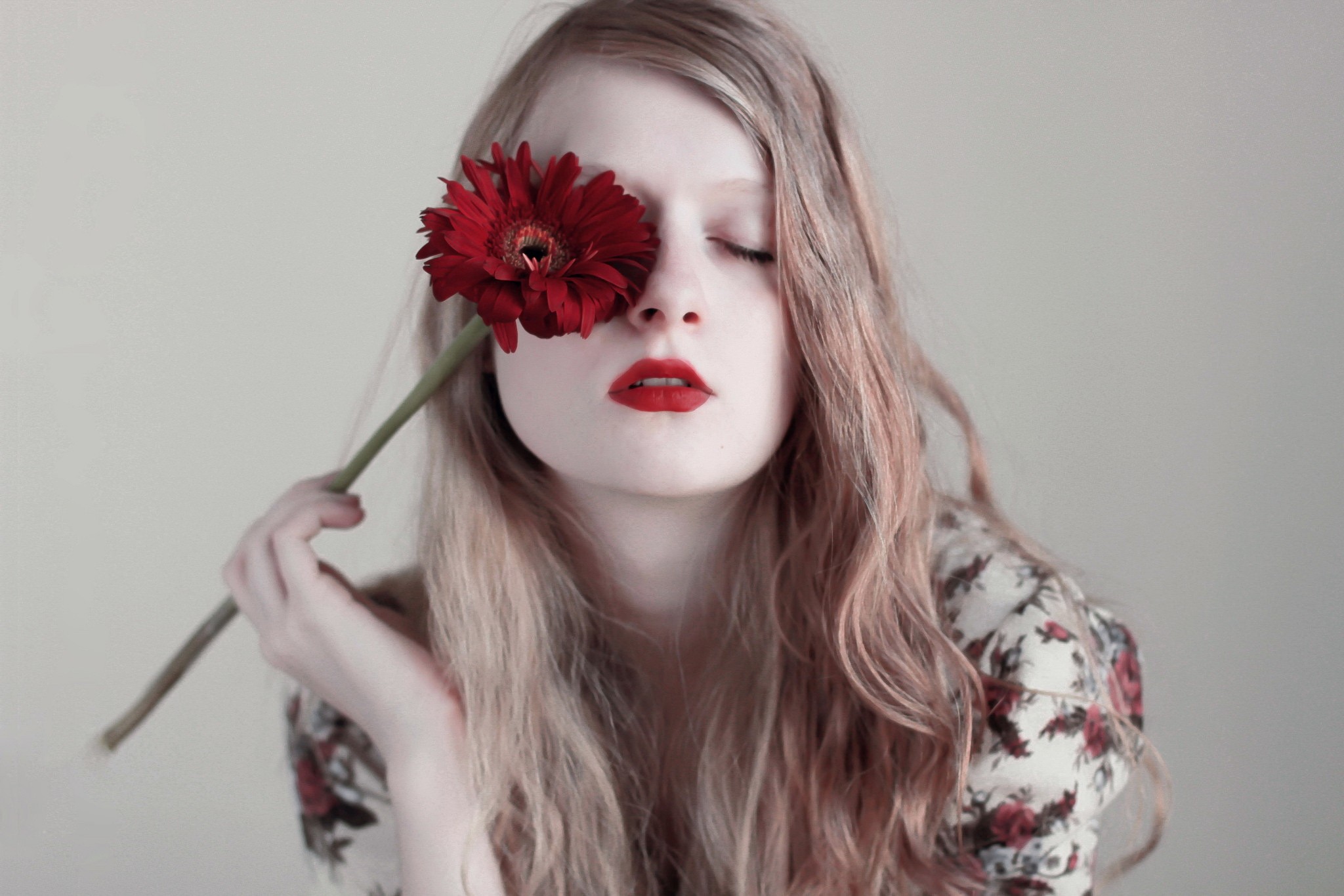 Woman holding a red flower over her eye HD Wallpaper
