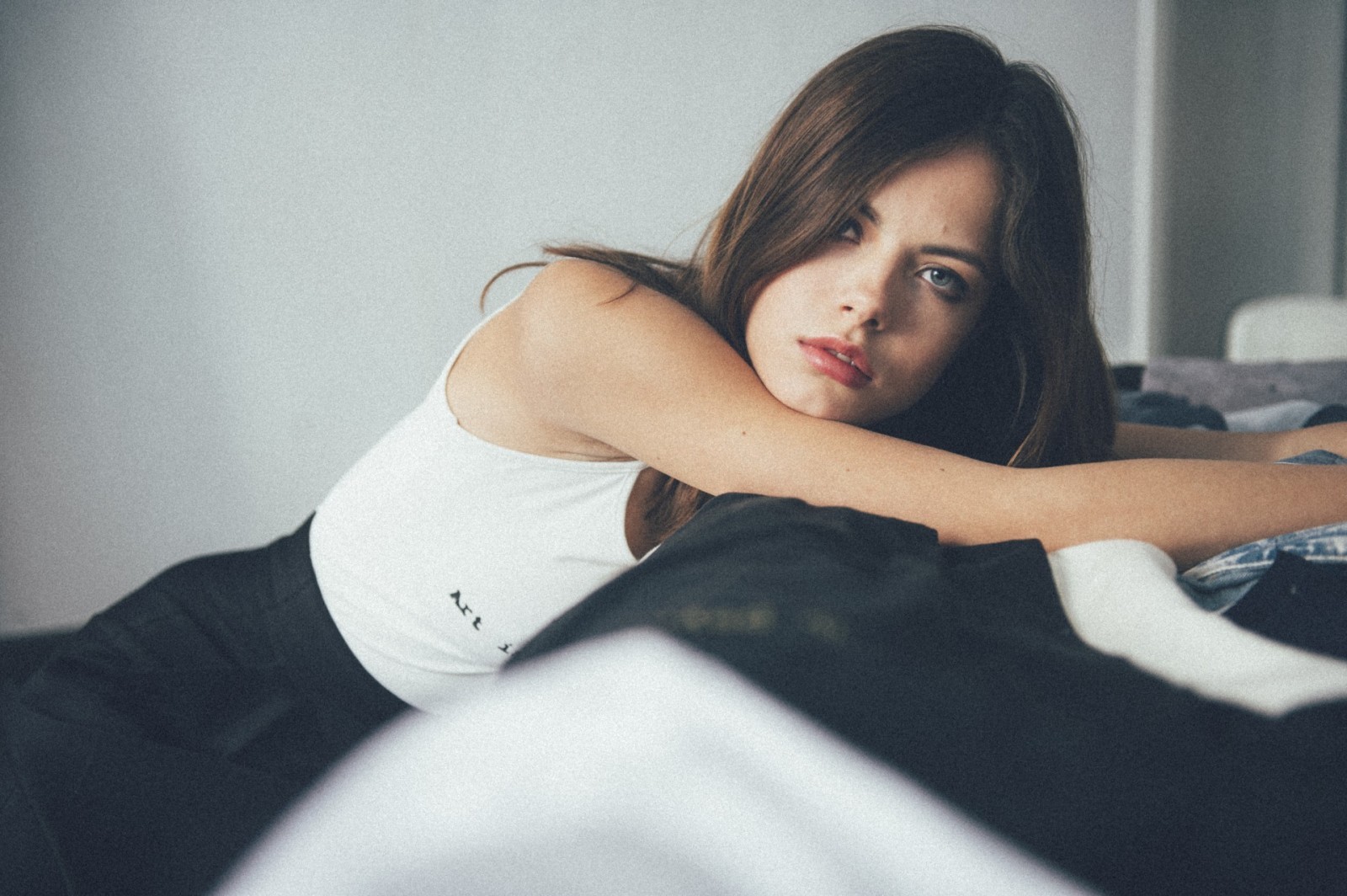 Brunette woman with blue eyes lying down HD Wallpaper