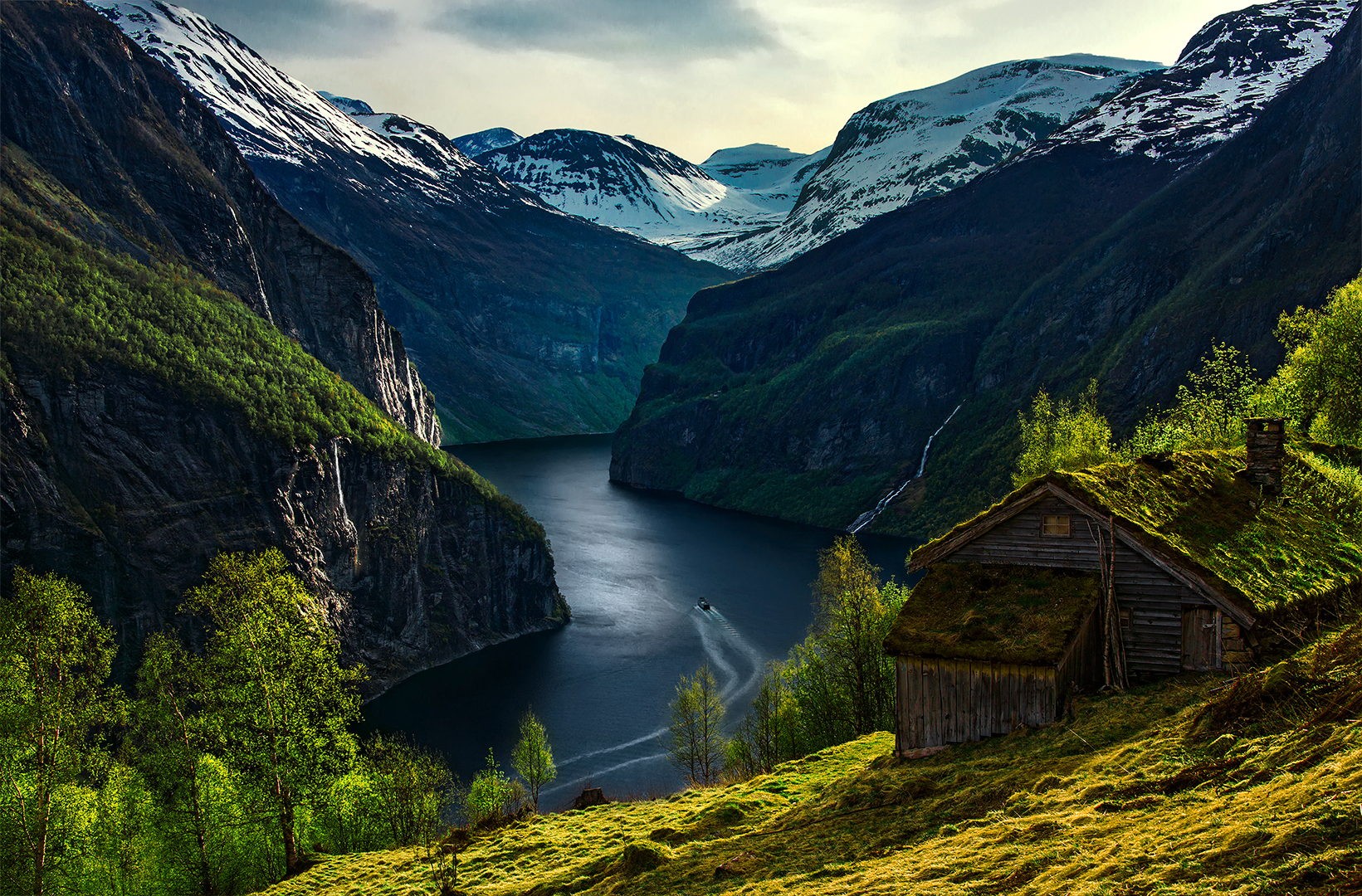 Wooden cabin in a Norwegian fjord with snow-capped mountains HD Wallpaper
