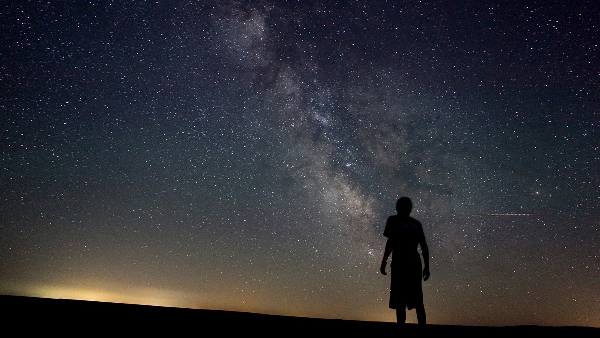 Silhouette of a person under the Milky Way galaxy HD Wallpaper
