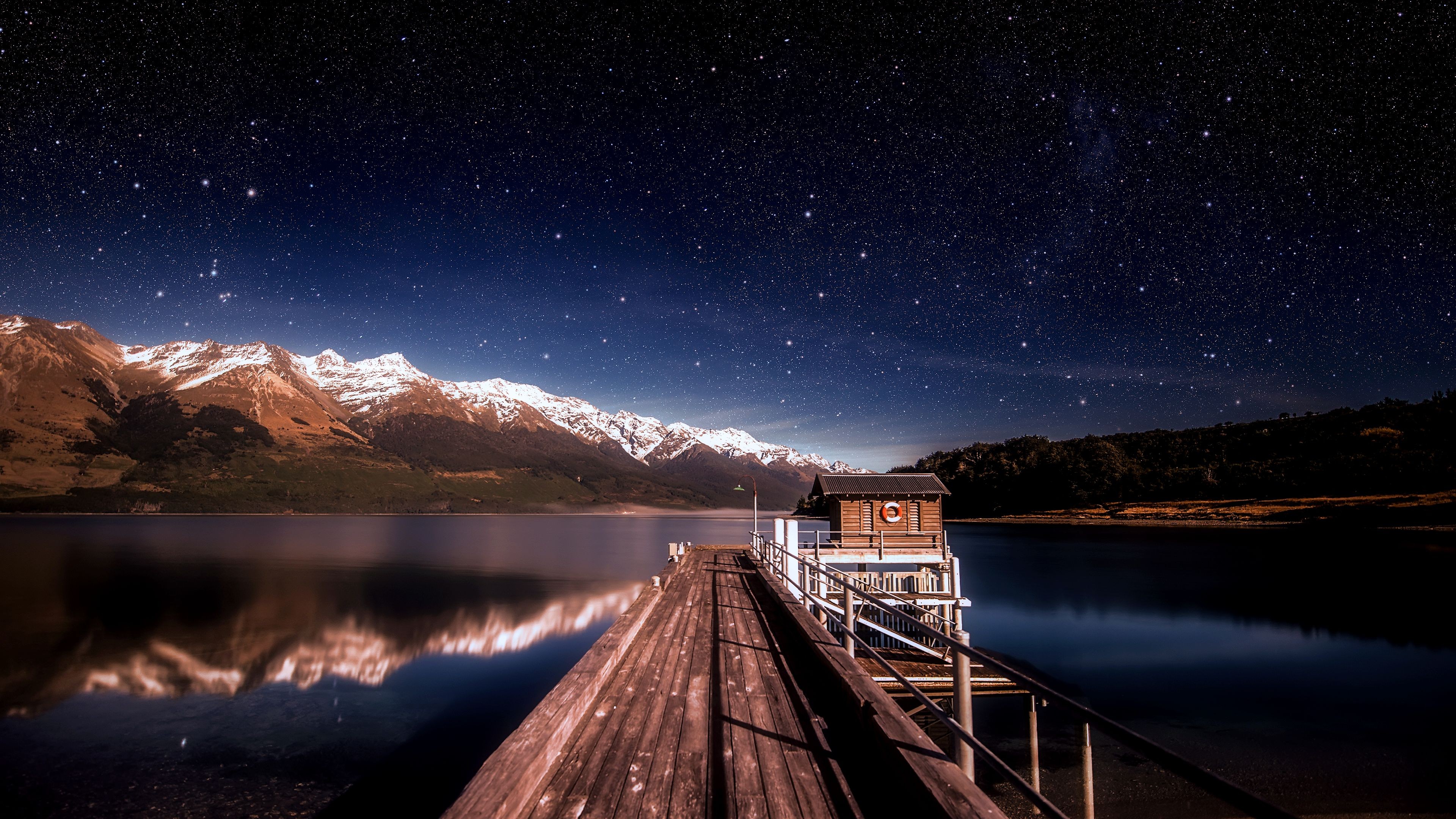 Wooden pier with a small cabin under a starry sky HD Wallpaper
