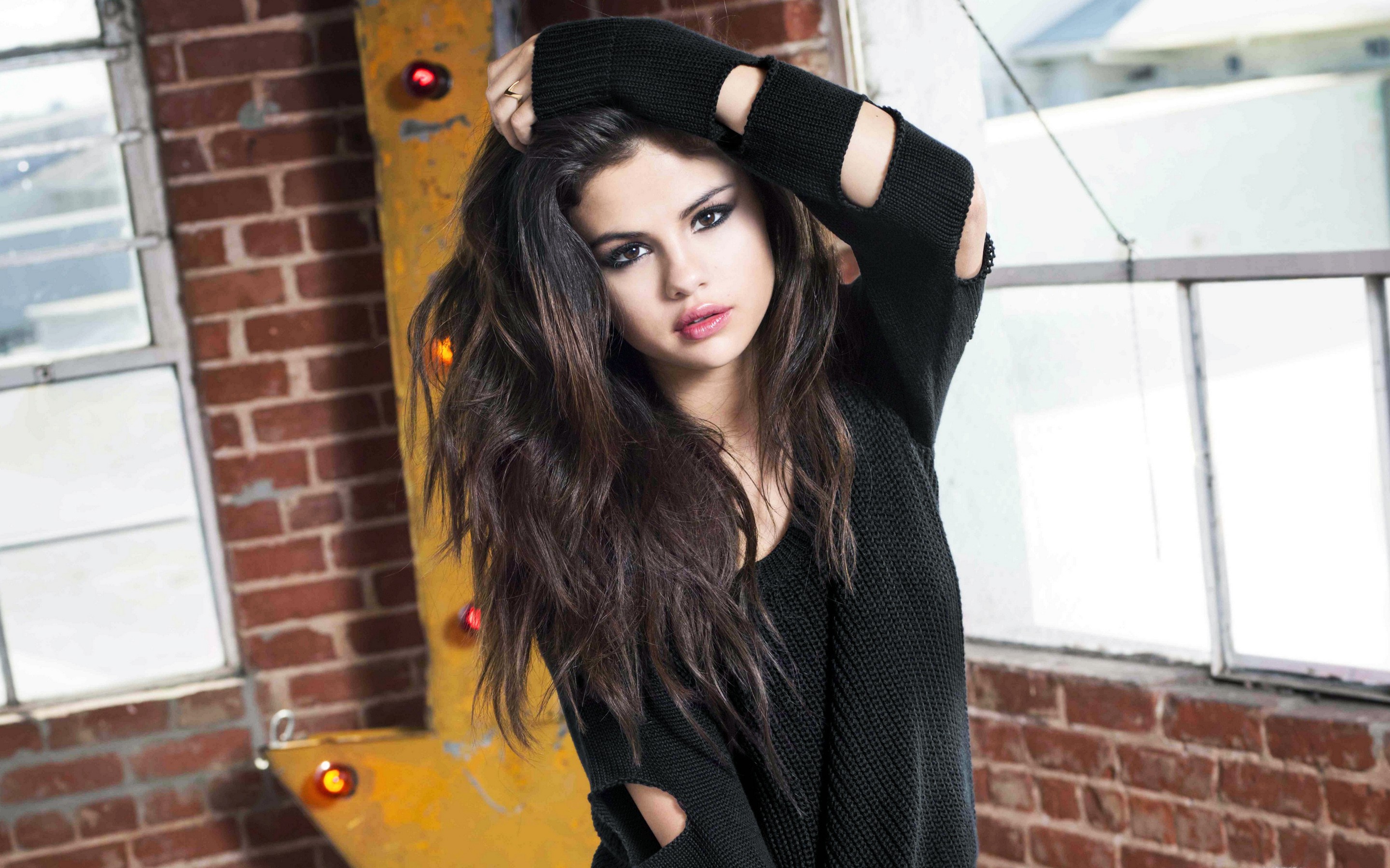 Selena Gomez posing in a black sweater HD Wallpaper