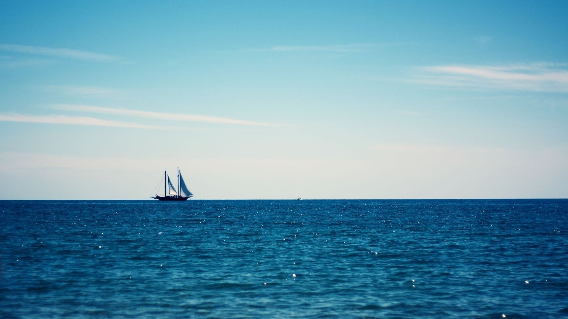 Sailing ship on the horizon under a blue sky HD Wallpaper