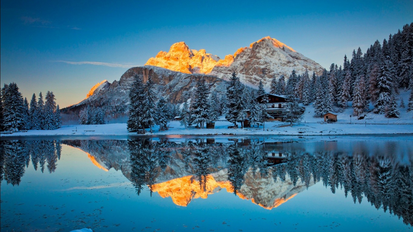 Snowy mountains reflected in a lake at sunrise HD Wallpaper