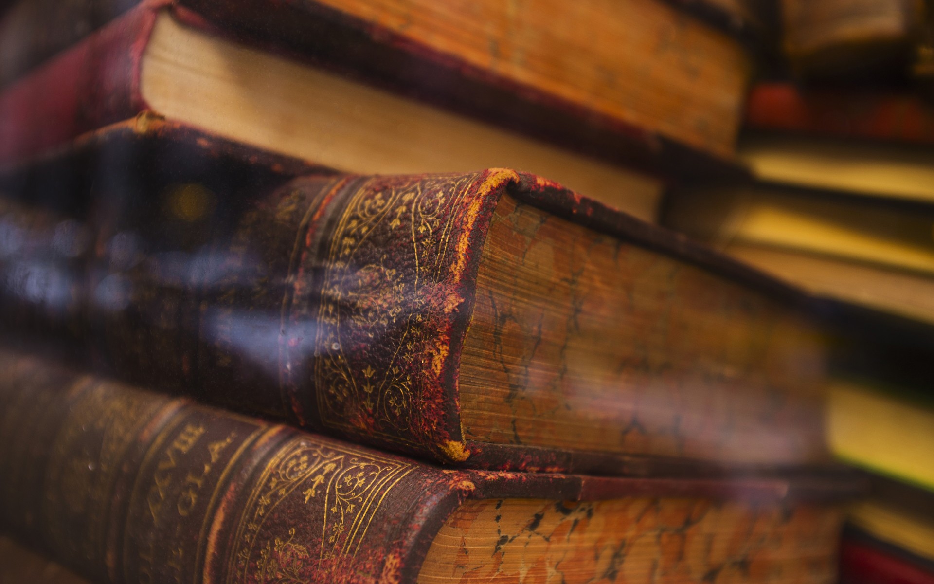 Stack of old books with ornate bindings HD Wallpaper