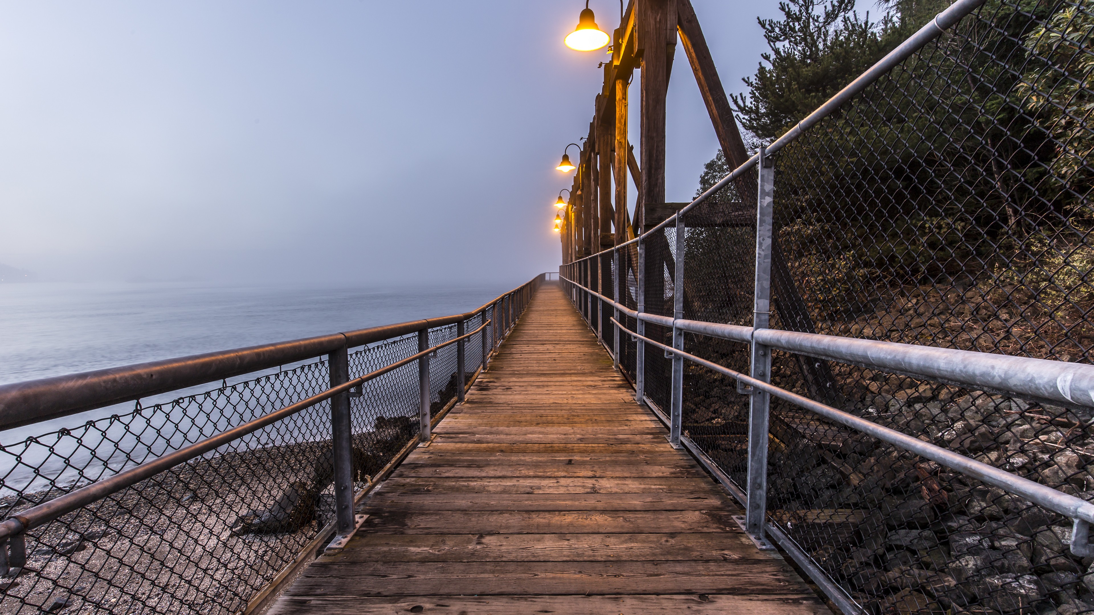 Wooden pier with lights over the ocean at dusk HD Wallpaper