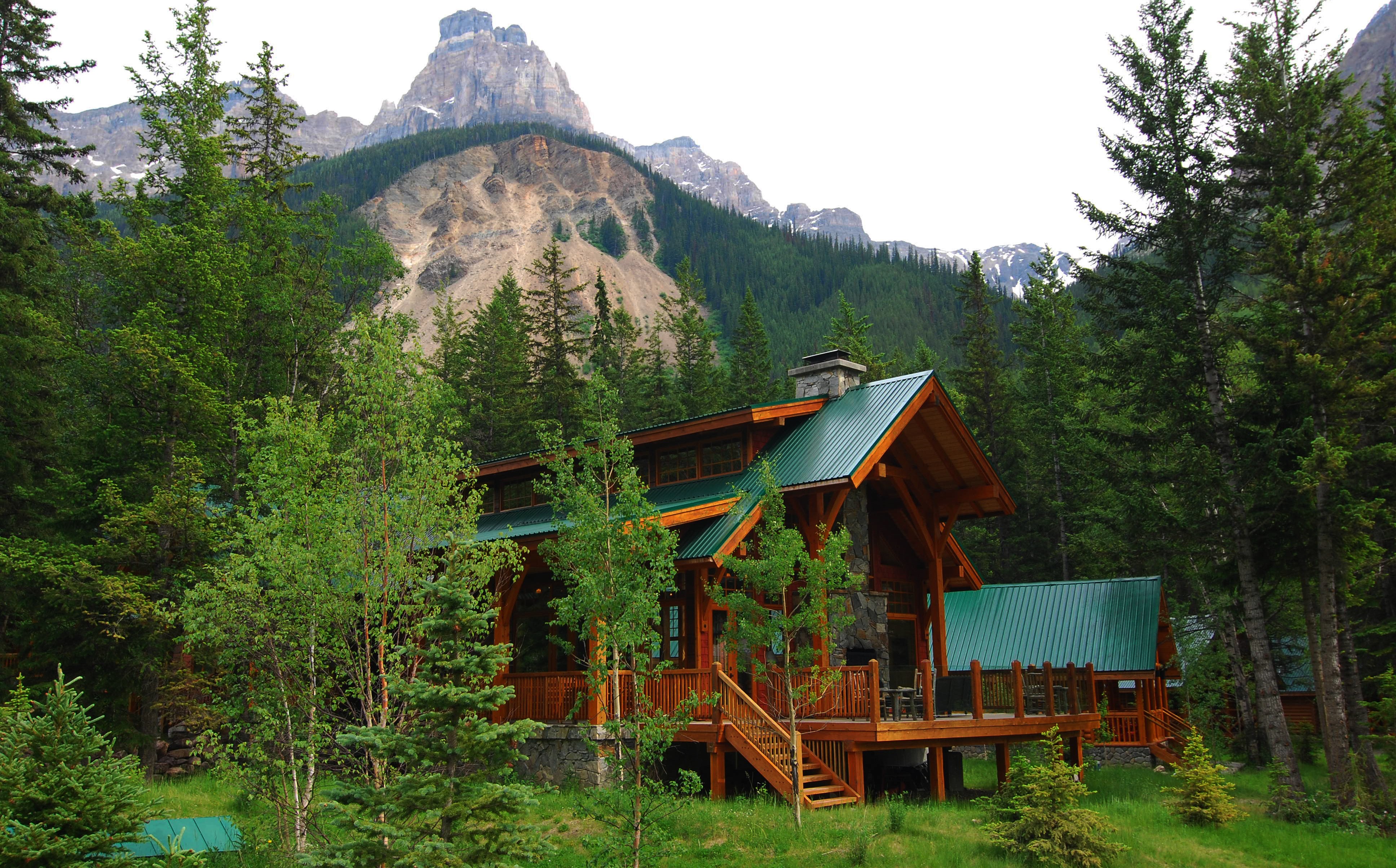Wooden cabin in a forest with mountains in Alberta, Canada HD Wallpaper