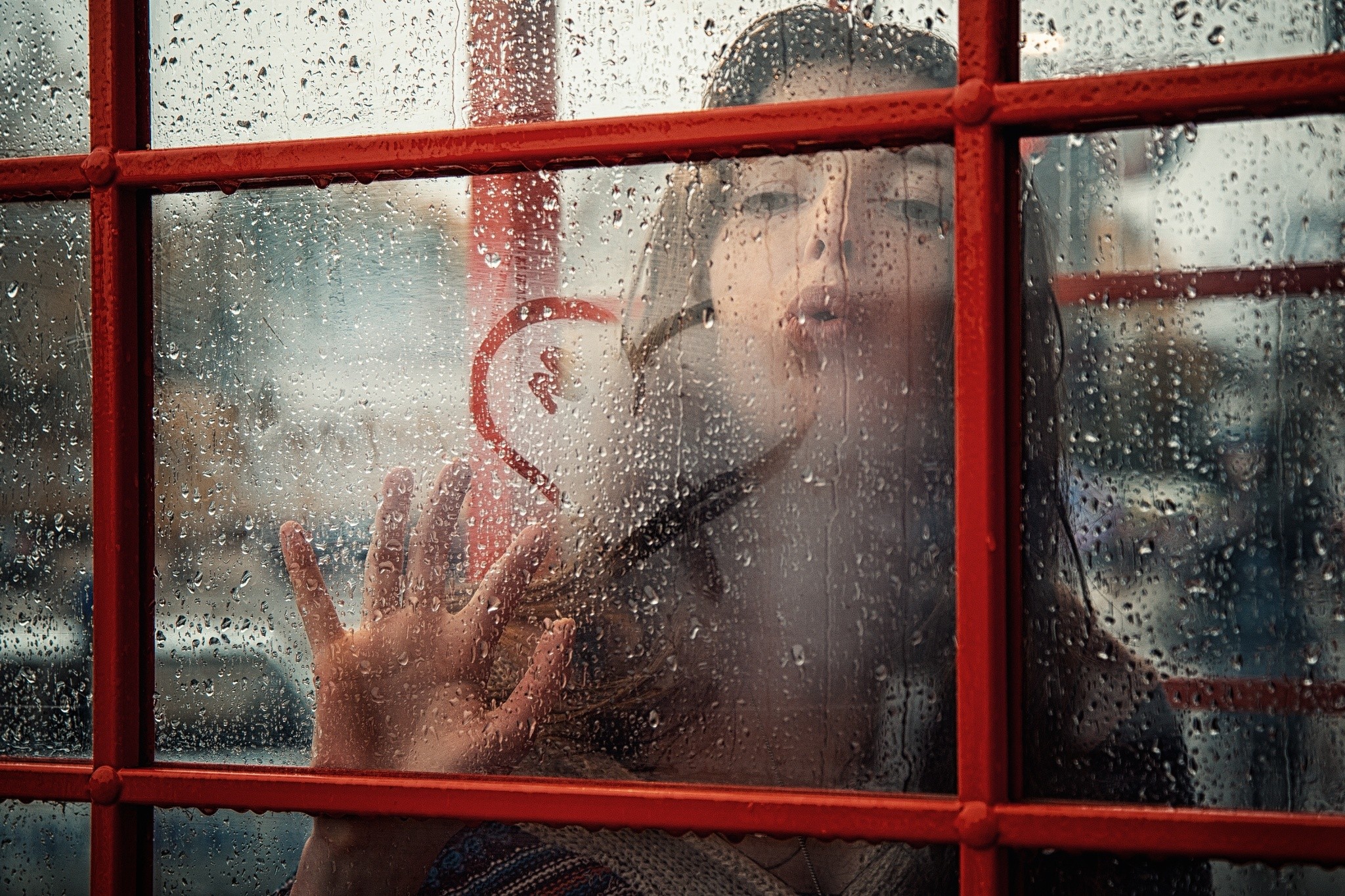 Woman drawing heart on rainy window HD Wallpaper