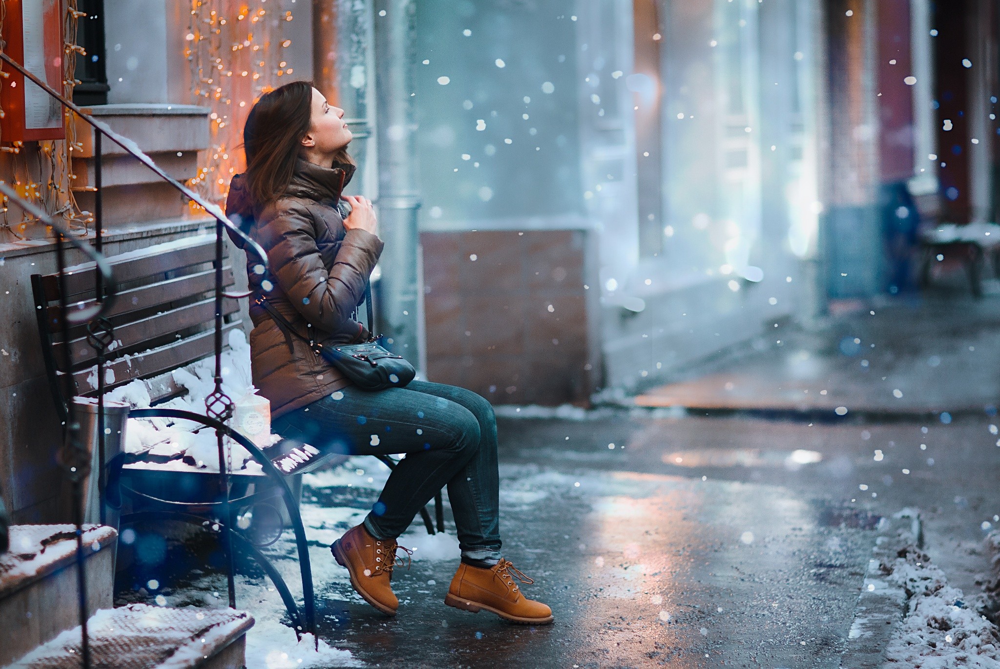 Woman sitting on a bench in the snow HD Wallpaper