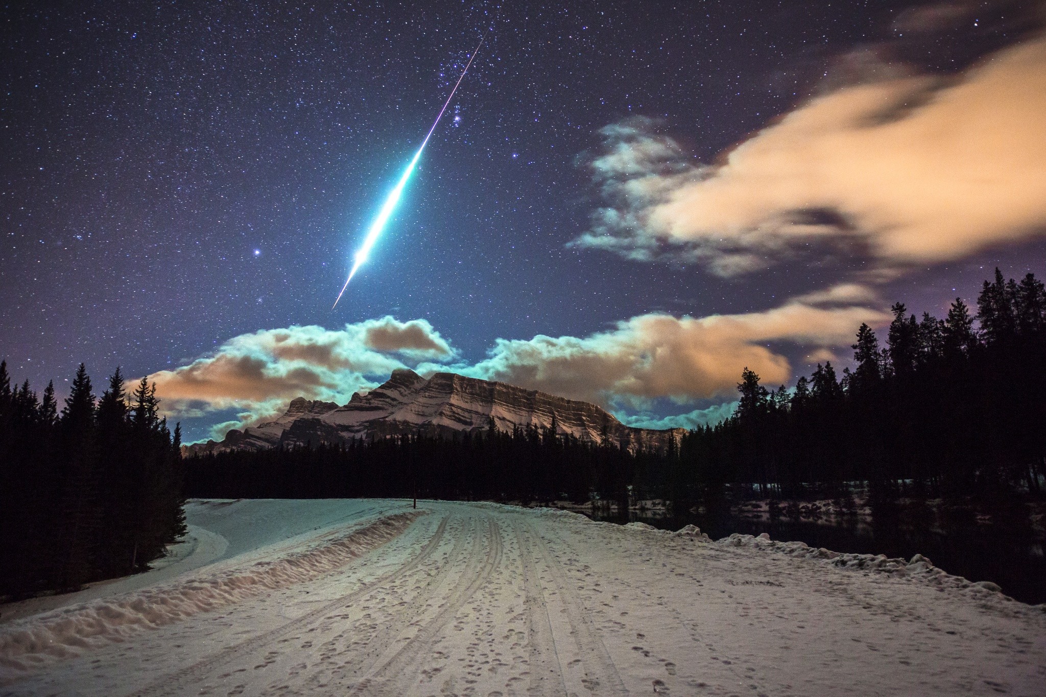 Meteor shower over snowy mountains and forest HD Wallpaper