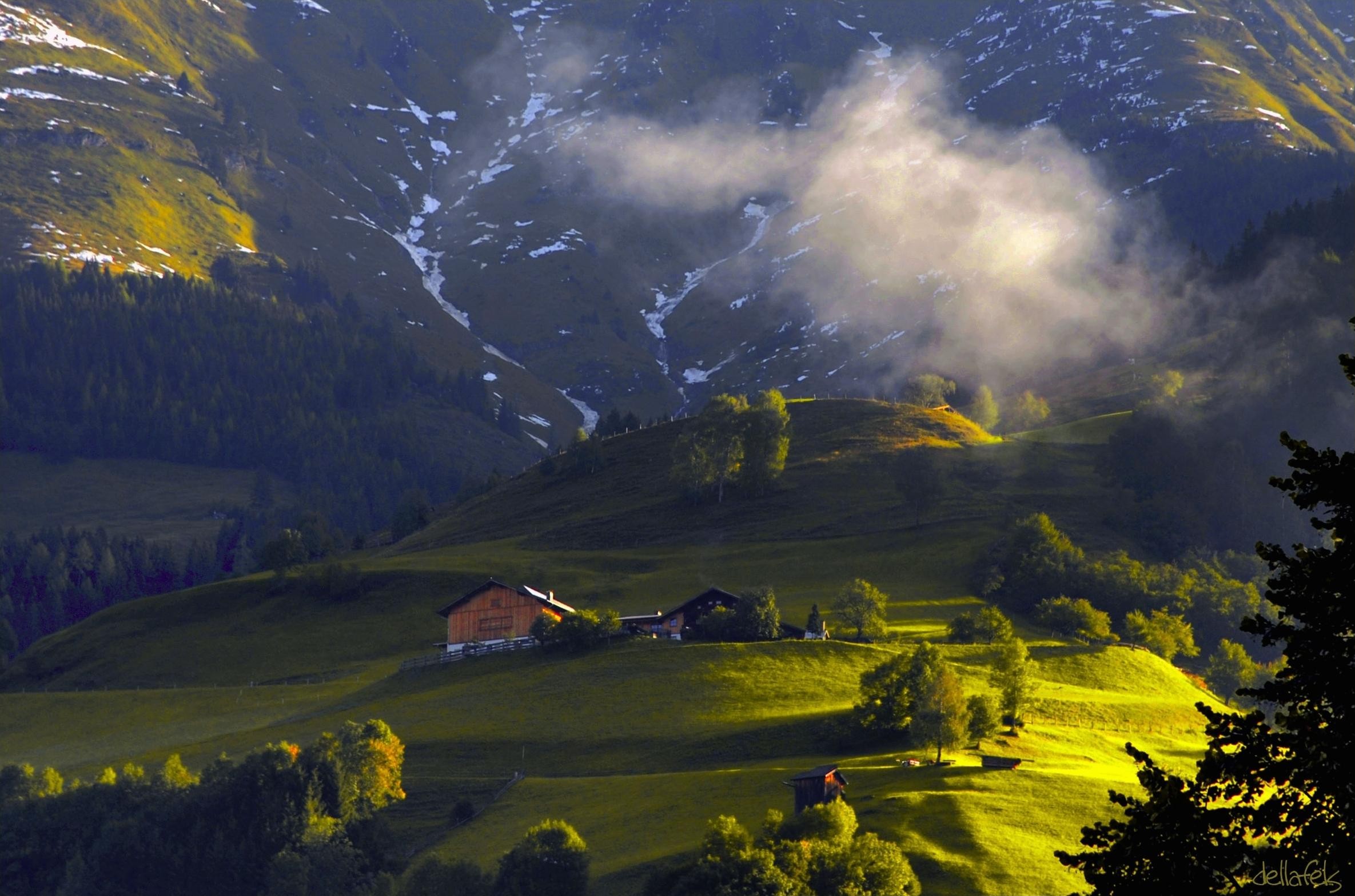 Alpine landscape with cabins and misty mountains in Austria HD Wallpaper