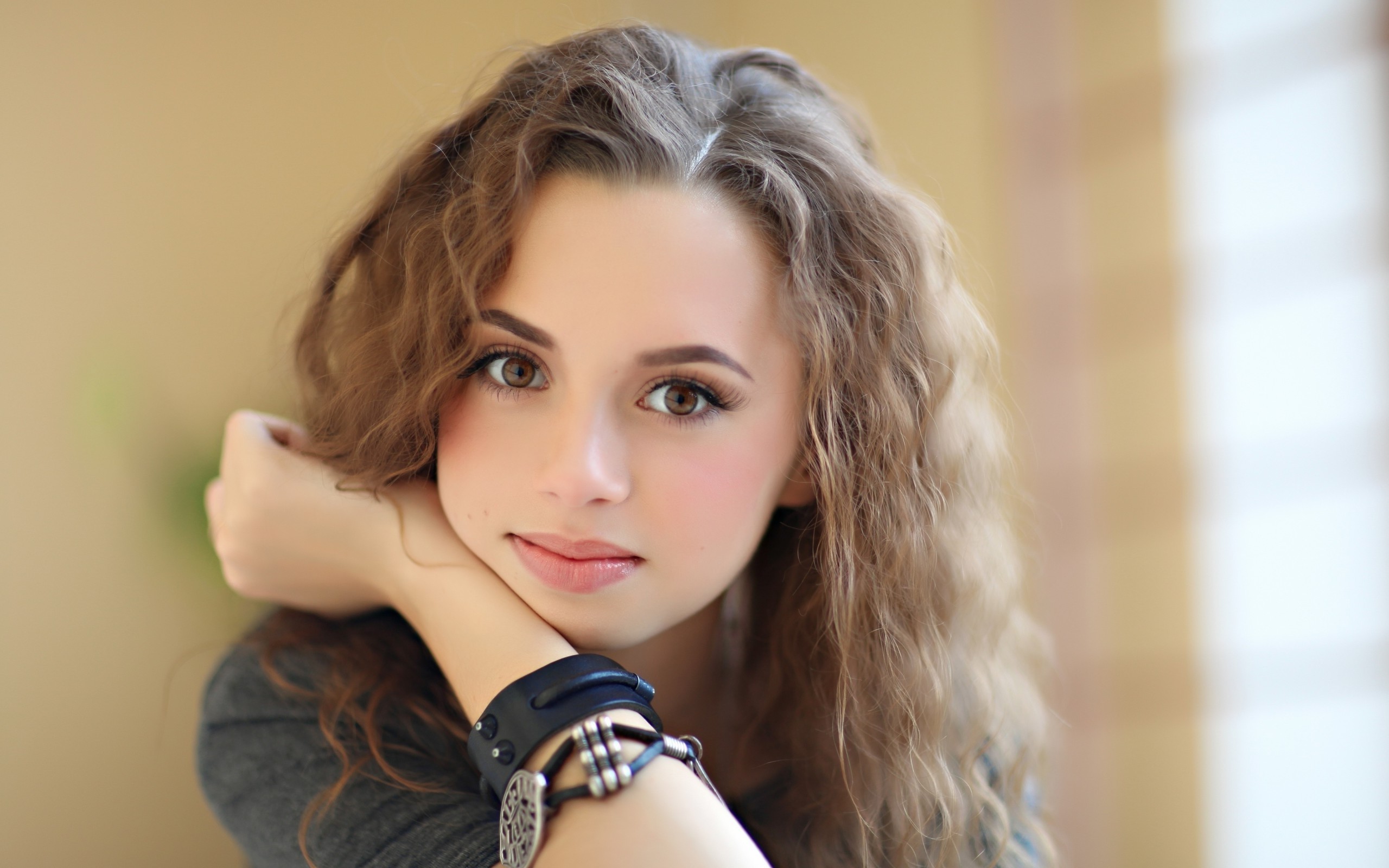 Young woman with curly brown hair and brown eyes HD Wallpaper