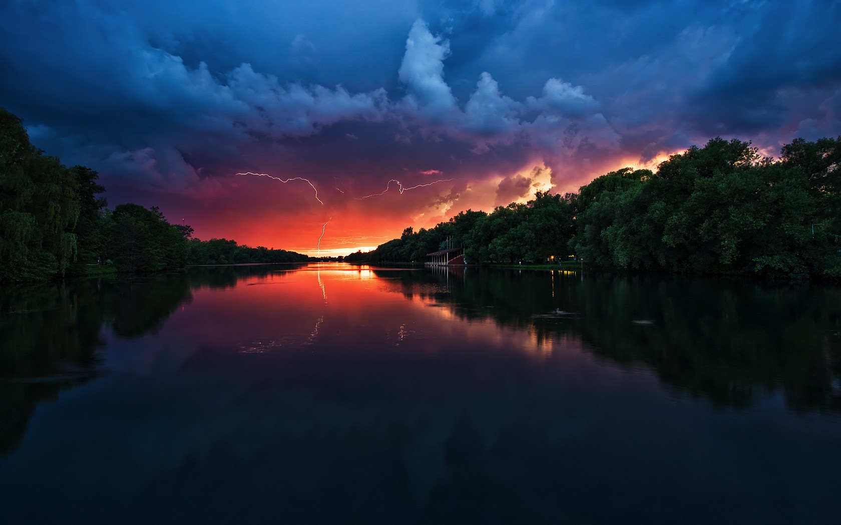 Lightning strikes over a river at sunset HD Wallpaper