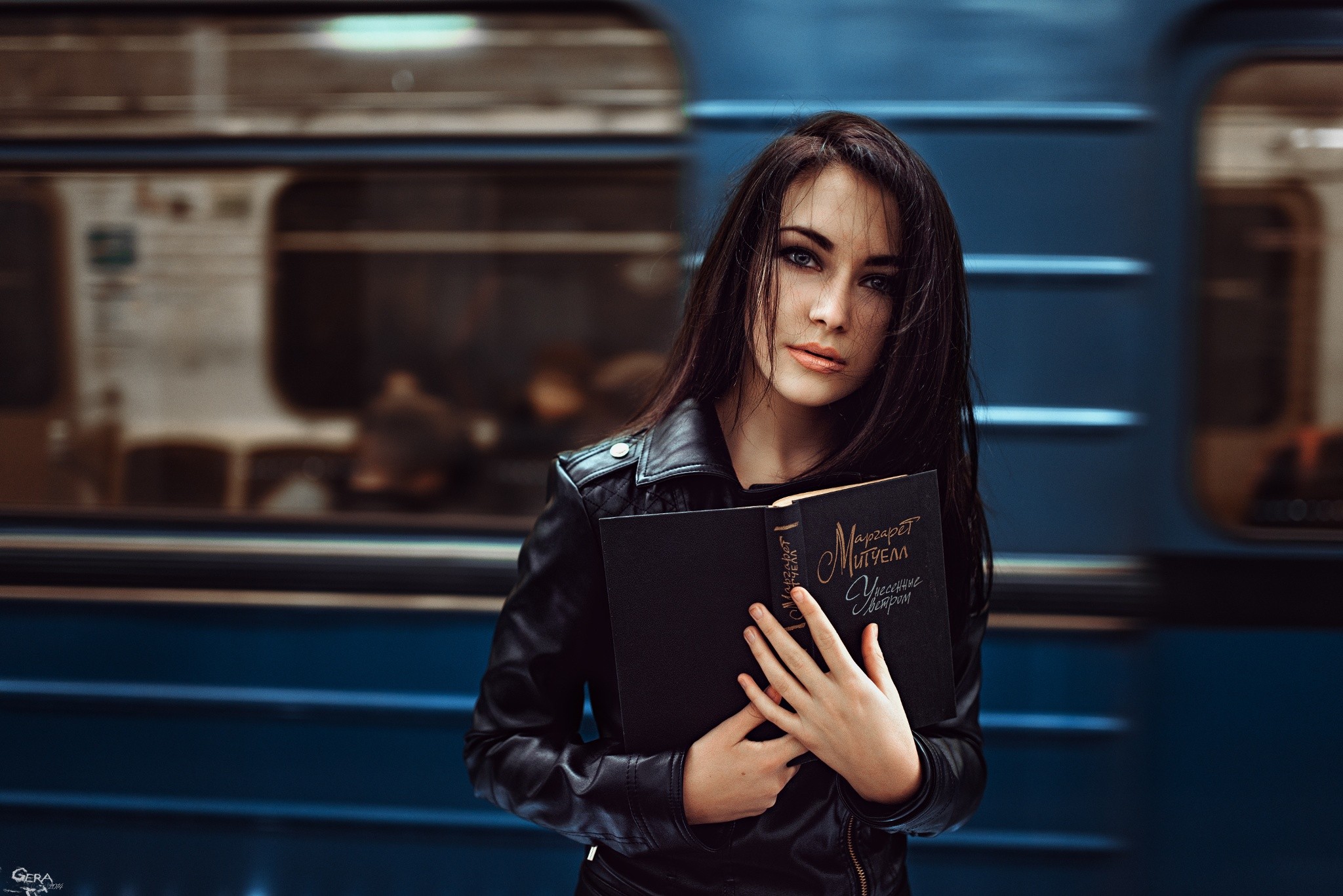Woman holding books in front of M3 Metro train HD Wallpaper