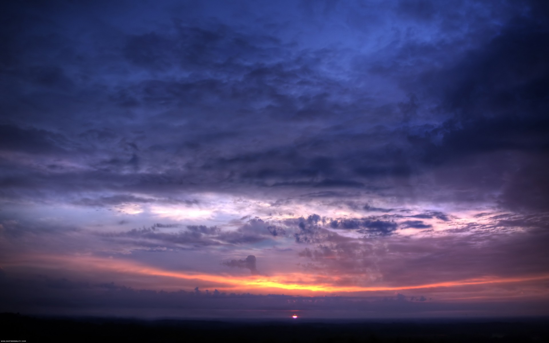 Sunset over a dark landscape with clouds HD Wallpaper
