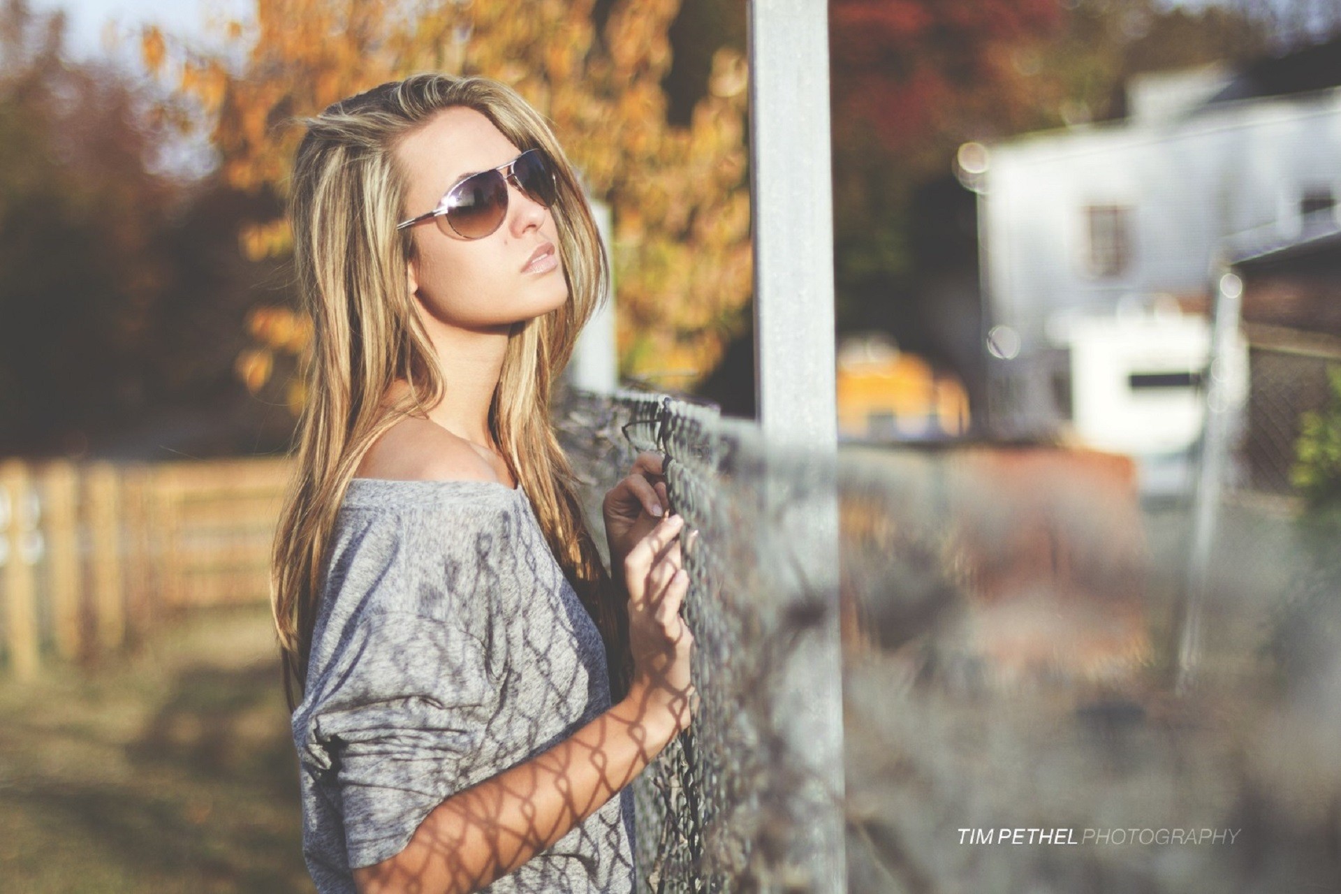 Woman with sunglasses leaning on a fence HD Wallpaper