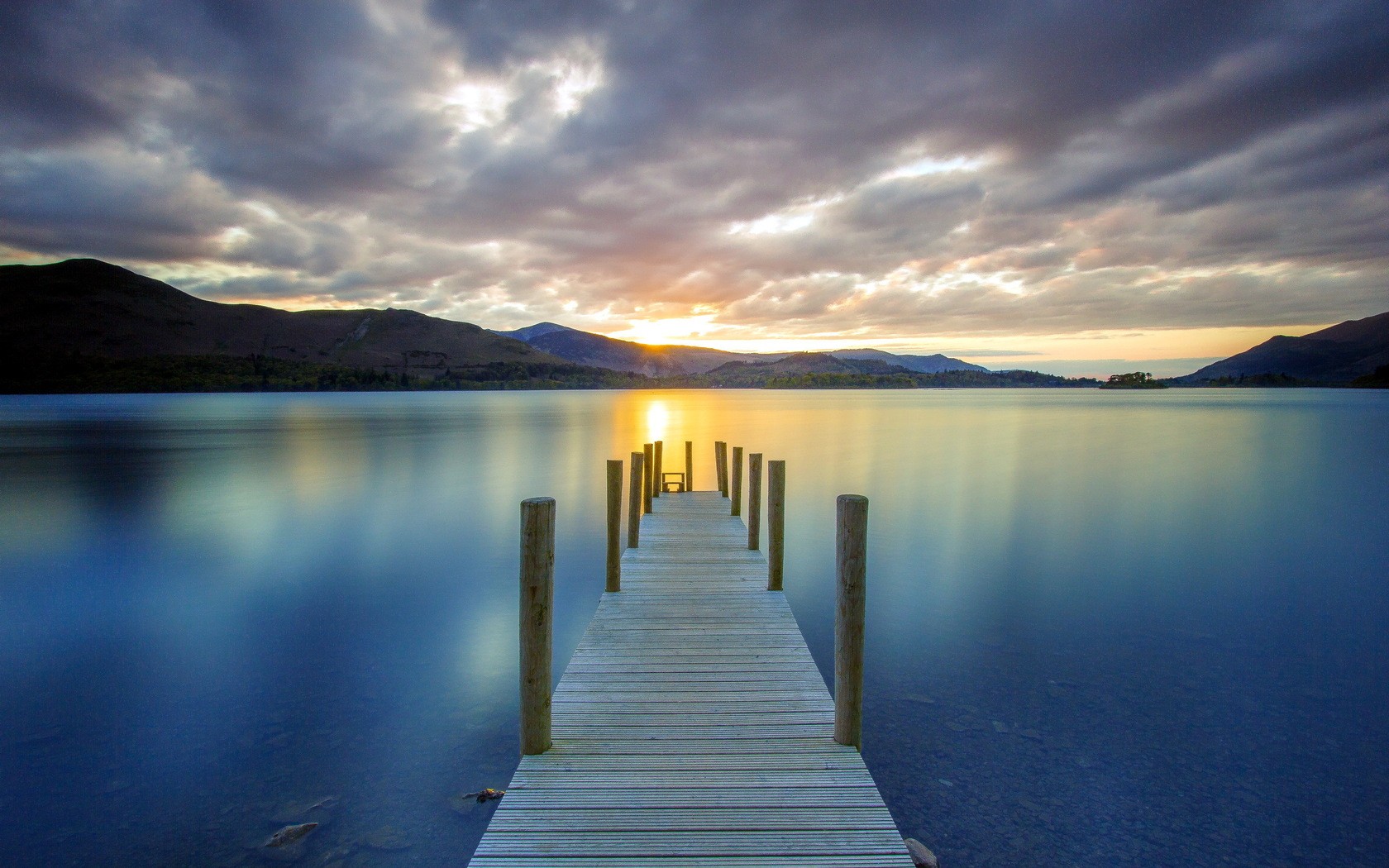Sunset over a calm lake with a wooden pier HD Wallpaper
