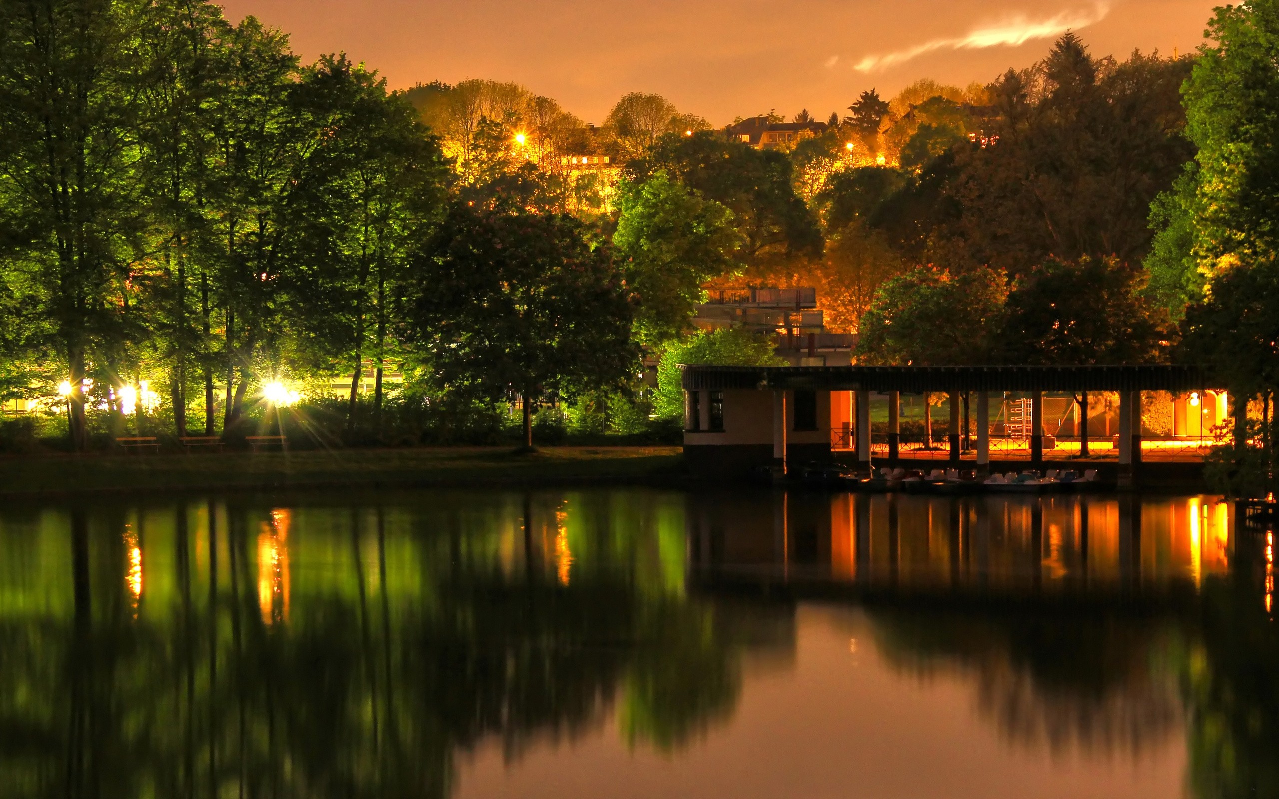 Lake with illuminated building and trees at dusk HD Wallpaper