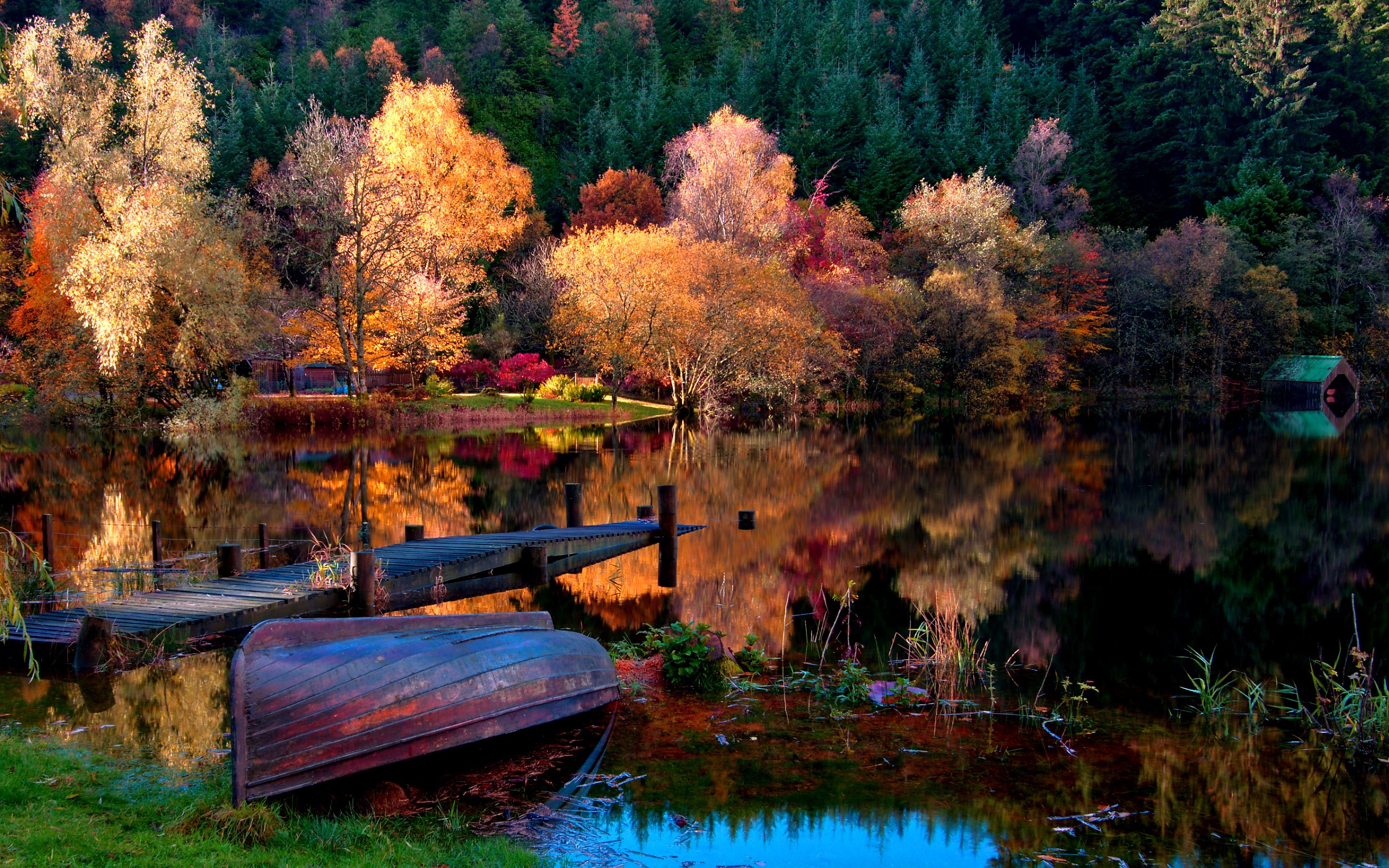 Autumn lake with a wooden dock and an overturned boat HD Wallpaper