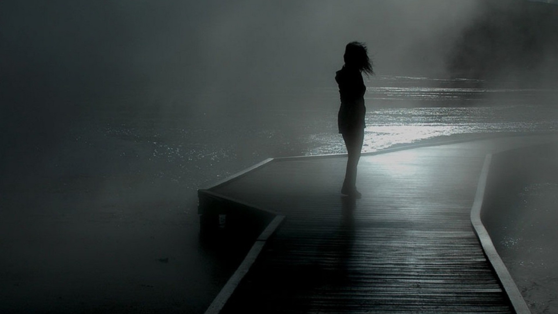 Silhouette of a person on a misty boardwalk HD Wallpaper