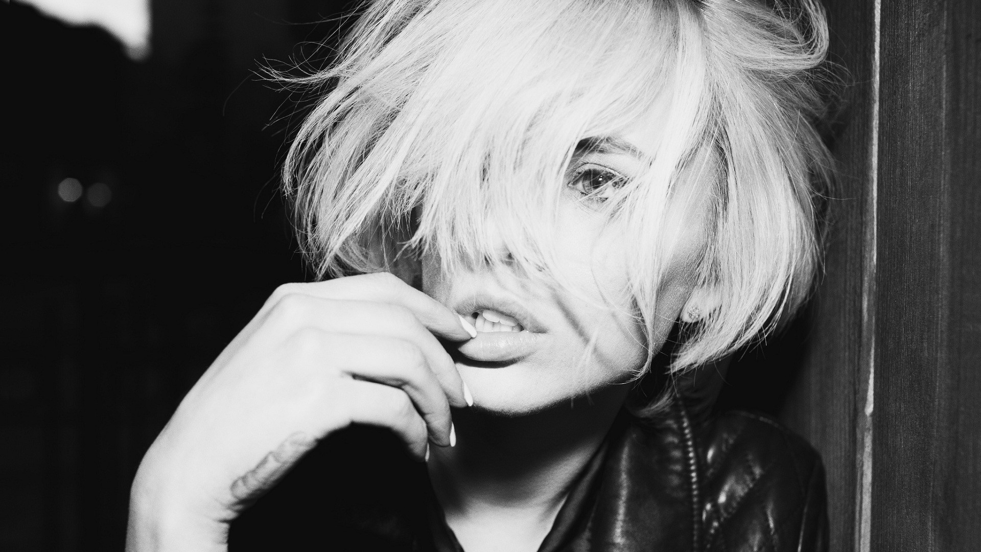 Monochrome portrait of a blonde woman with hand near mouth HD Wallpaper