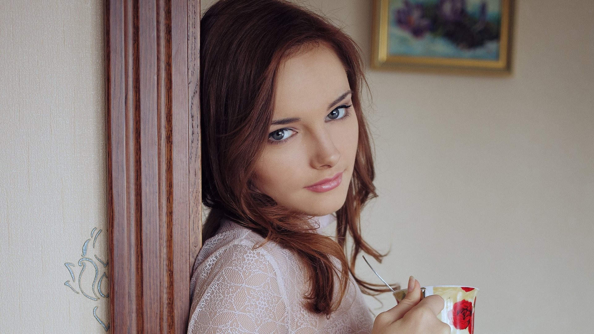 Woman with blue eyes holding a cup HD Wallpaper
