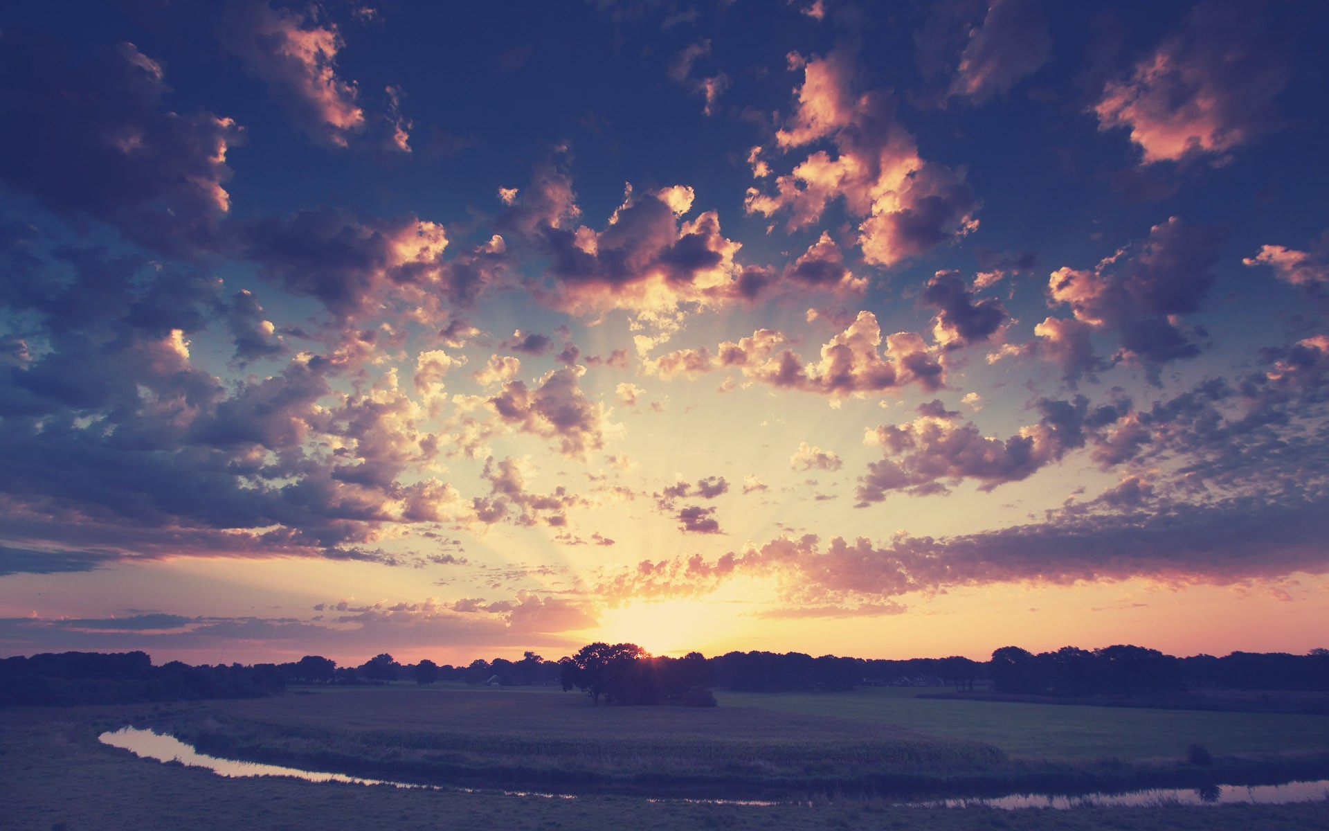Sunset over a river and fields with dramatic clouds HD Wallpaper