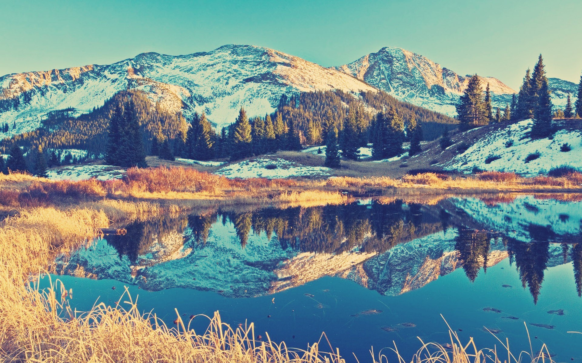 Snow-capped mountains reflected in a calm lake HD Wallpaper