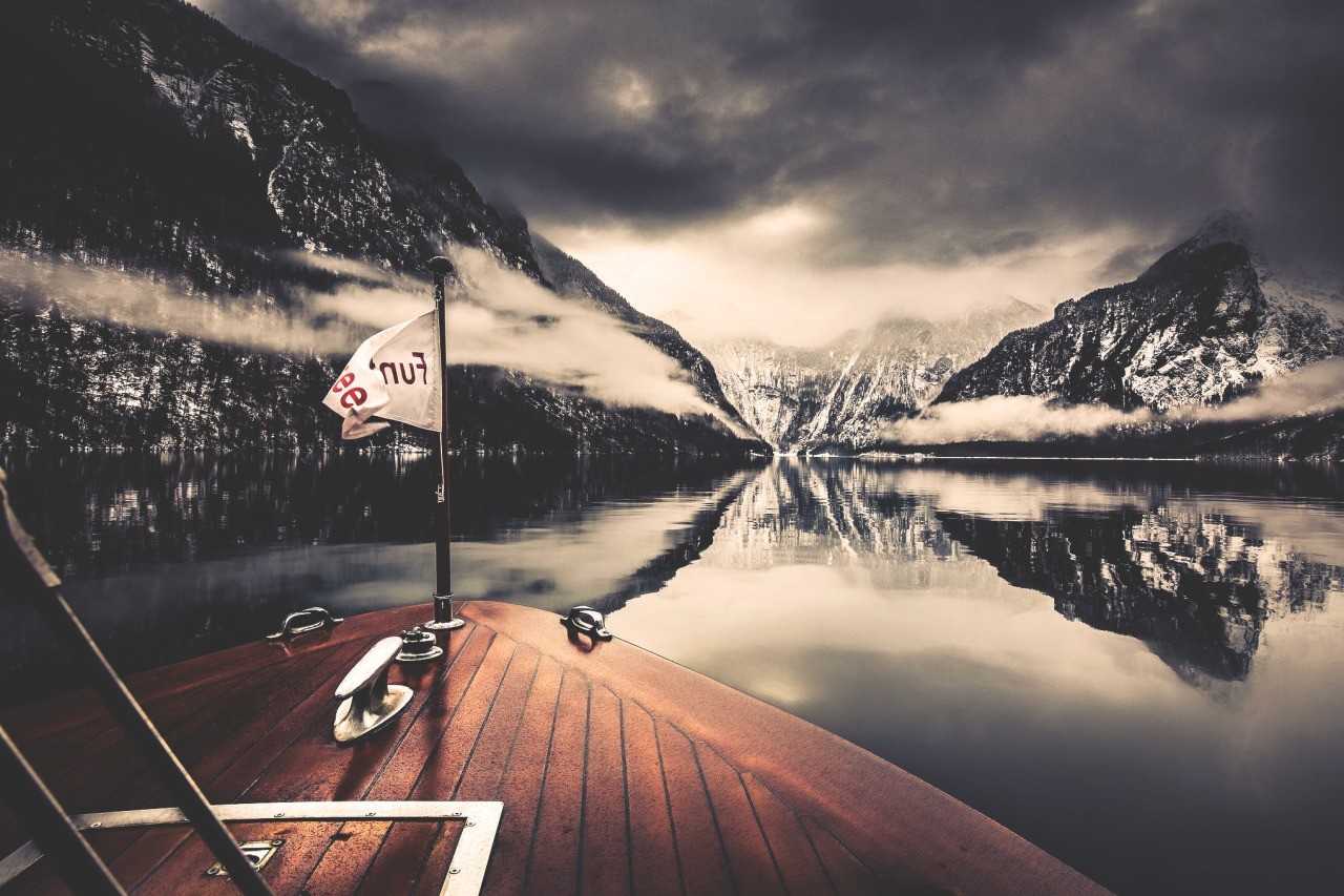 Boat on a lake with snow-capped mountains and reflection HD Wallpaper